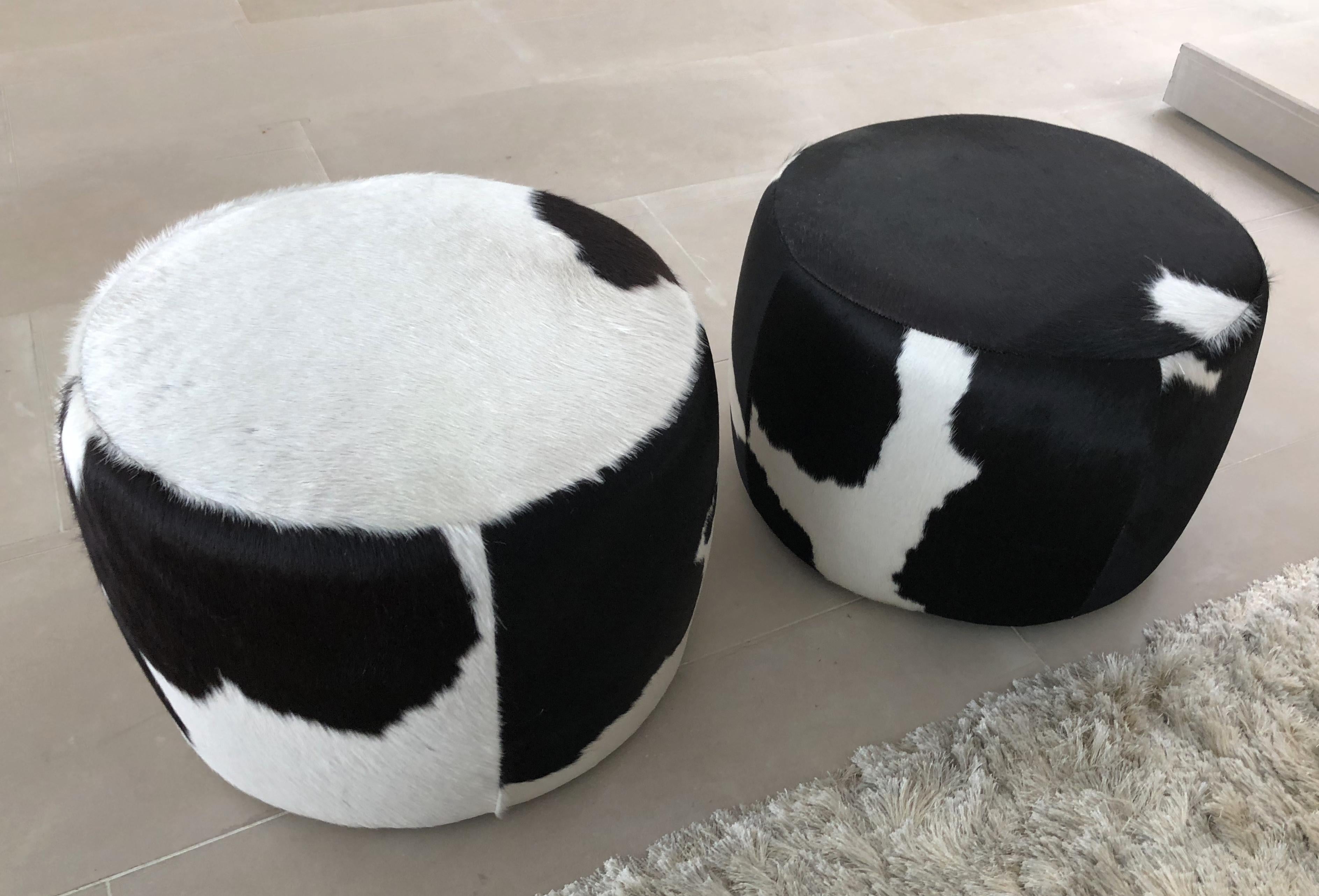 Beautiful set of two poufs or ottomans or foot stools upholstered in a beautiful cowhide material, the pieces are in excellent condition and they are ready to be used.

Measurements:
21