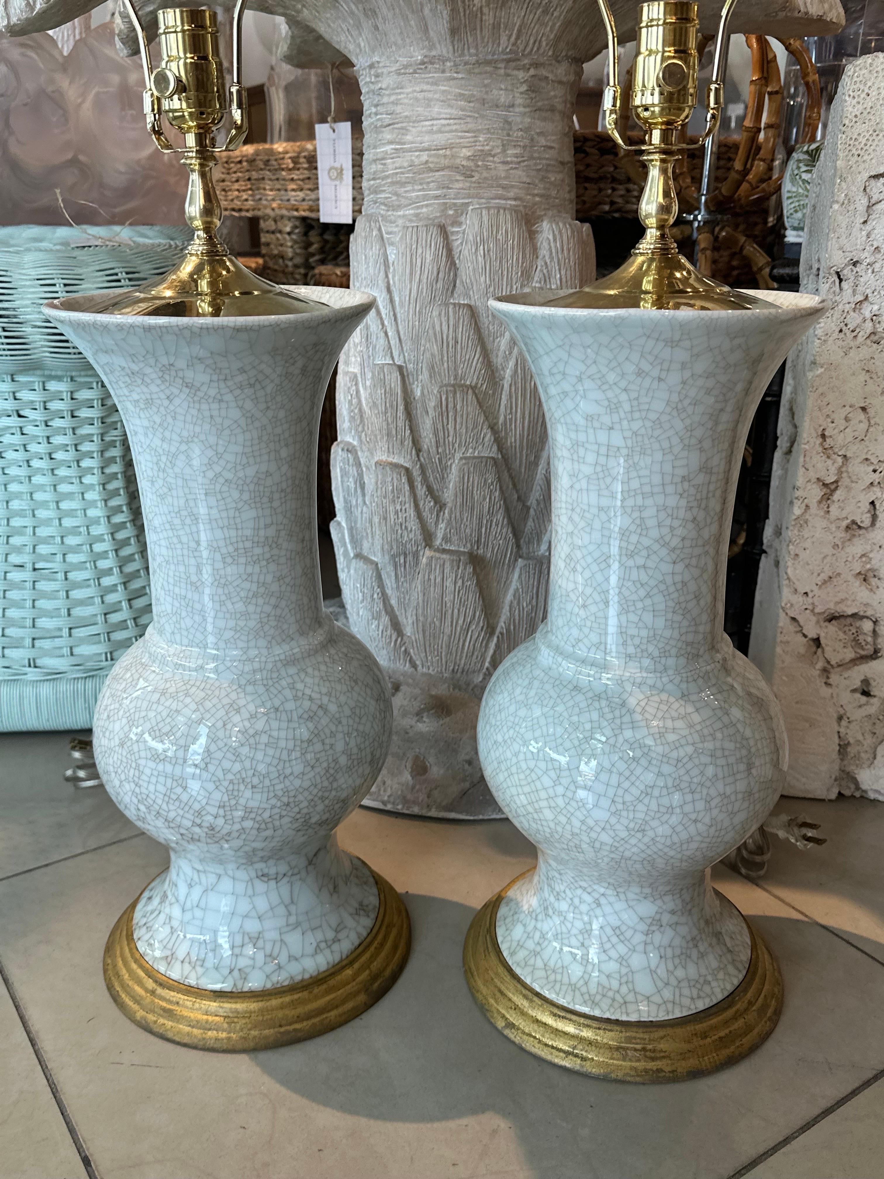 Lovely vintage pair of crackle glaze ceramic porcelain table lamps. These have been newly wired. All new brass hardware, clear cord, 3 way sockets. 
Measures: Height to socket 23 x Height to finial 31.5 H x 9 D. 