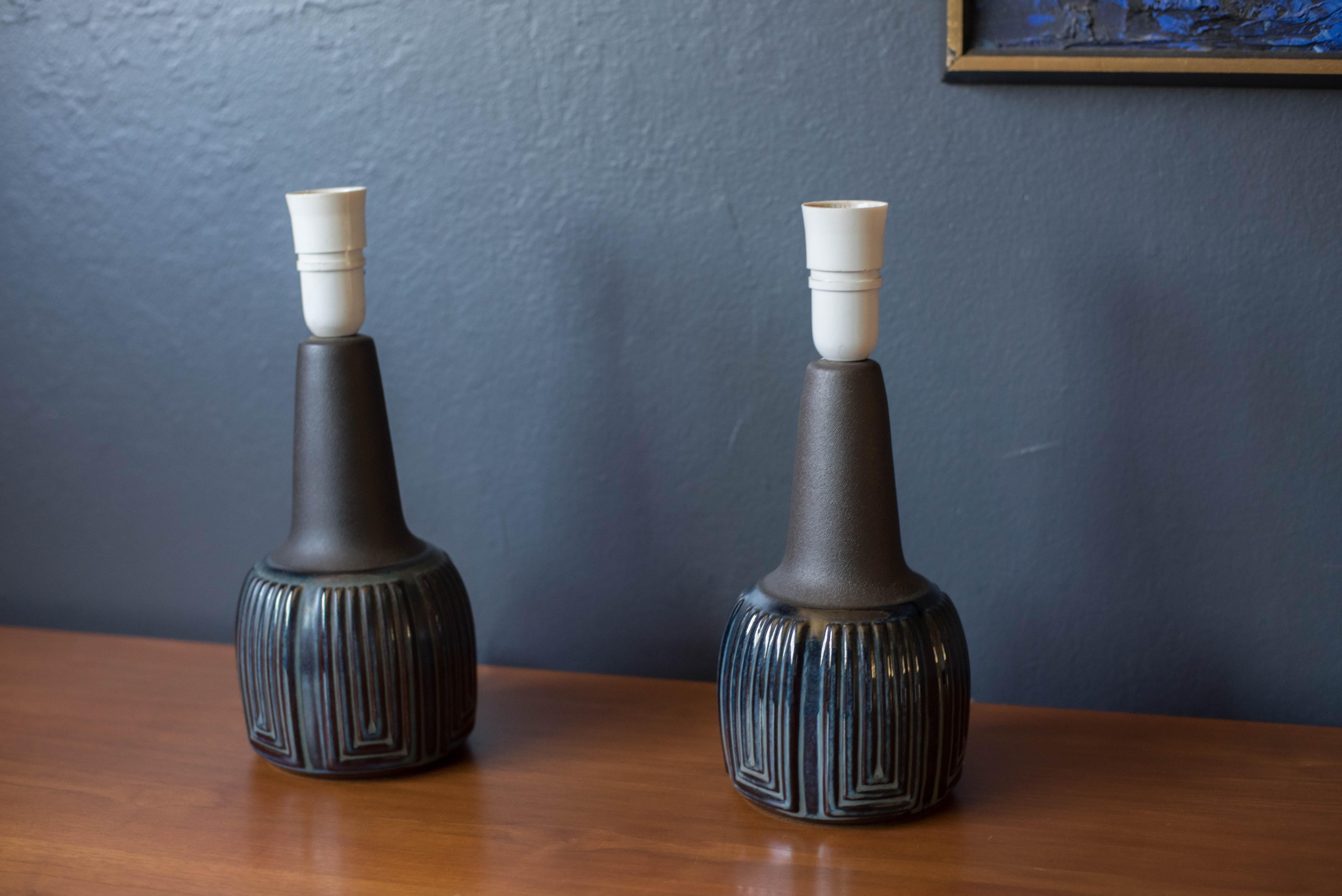 Mid-Century Modern pair of stoneware pottery lamps designed by Einar Johansen for Soholm Stentoj. This two-toned set has an engraved deep blue glaze finish and a textural matte black stem. Marked 1039 on the bottom and rewired for the US.



Offered