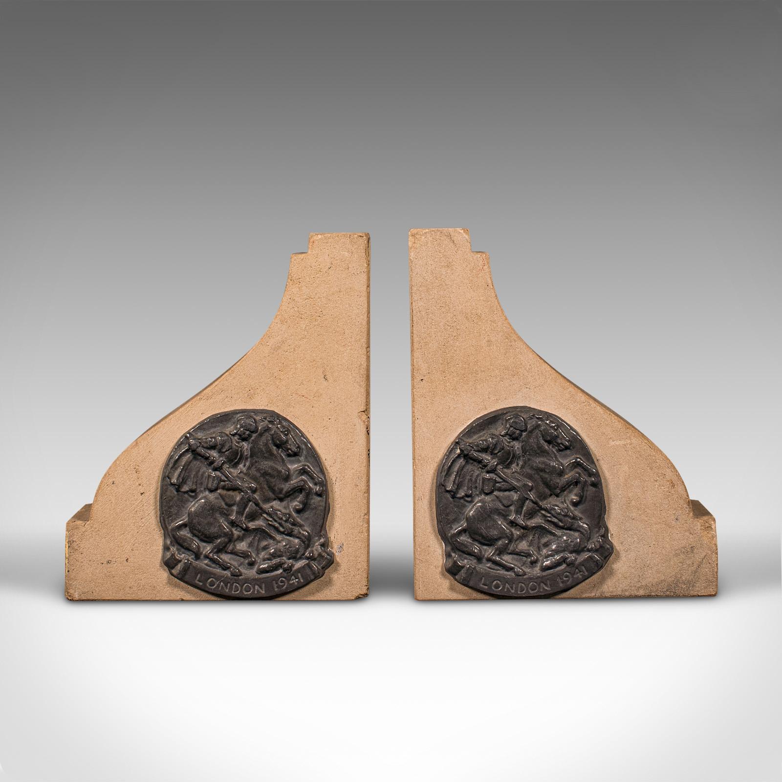 
Se trata de un par de sujetalibros decorativos vintage. Un atril inglés de piedra de Portland, de mediados del siglo XX, hacia 1940.

Formas agradablemente robustas con un atractivo emblema de la época de la 2ª Guerra Mundial
Mostrando una deseable