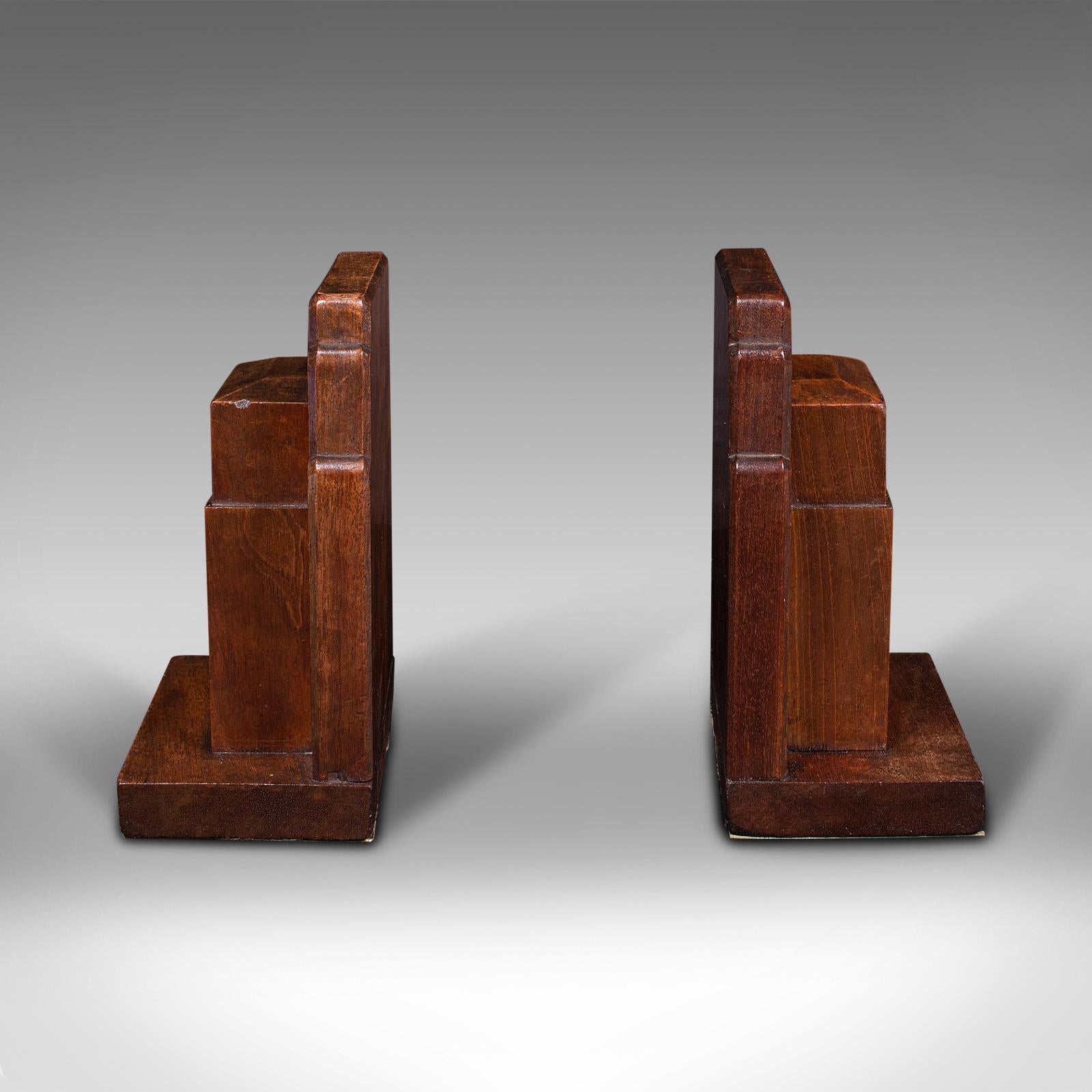 This is a vintage pair of decorative bookends. An English, walnut book rest by Gordon Russell Limited, dating to the early 20th century, circa 1930.

A dashing bookend set, with overtones of Russell's influence by the Arts & Crafts