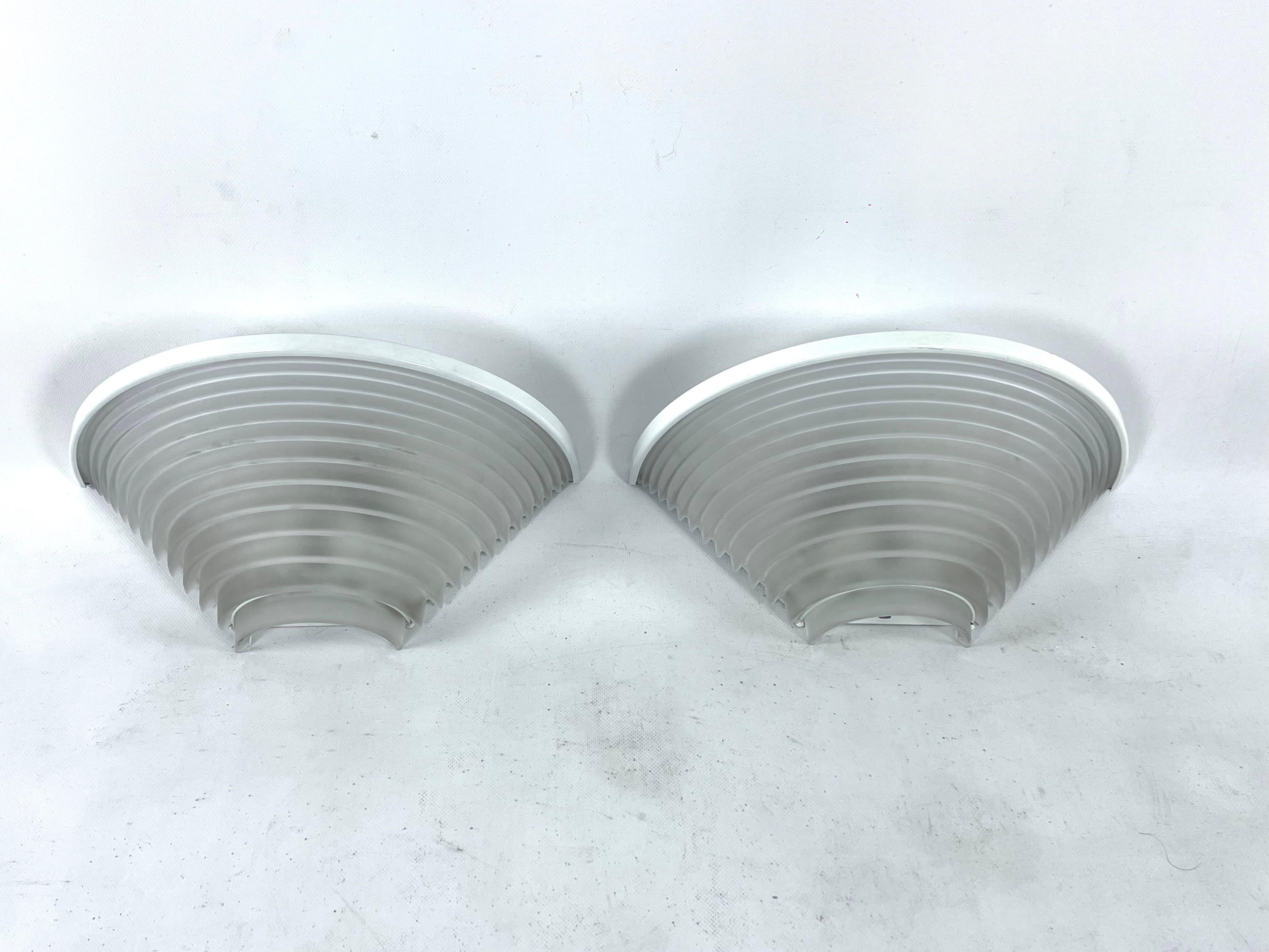 Great vintage condition with normal trace of age and use for this set of two egisto 38 parete designed by the Italian architect Angelo Mangiatotti for Artemide and produced during the 1980s. Made from thick frosted glass shade on white metal frame.
