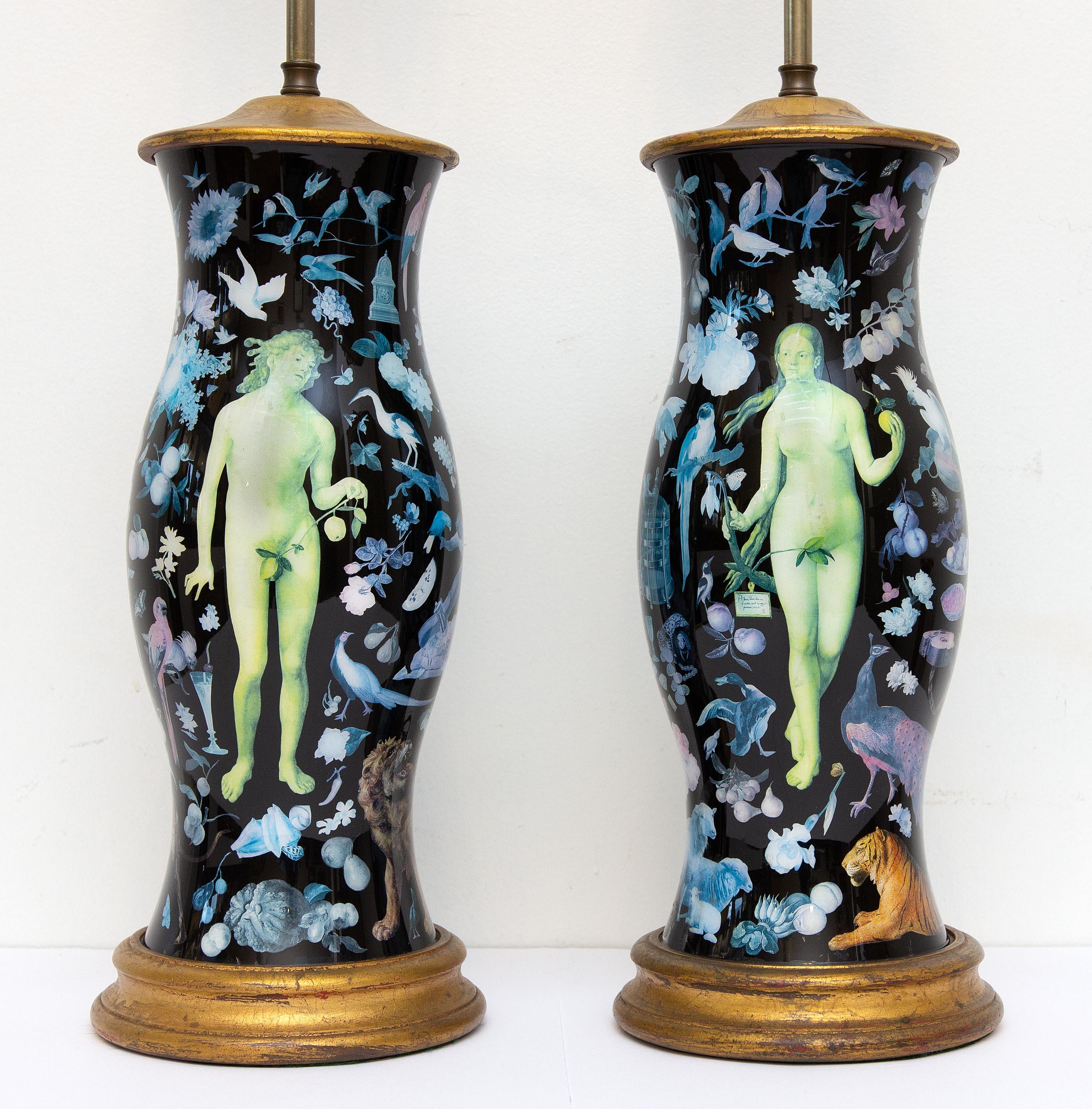Pair of decalcomania lamps. They are decorated with flora, fauna, and figures of Adam and Eve. Decalcomania, is a decorative technique by which engravings and prints may be cut and transferred. The bases are glass and decorated on the interior. Very
