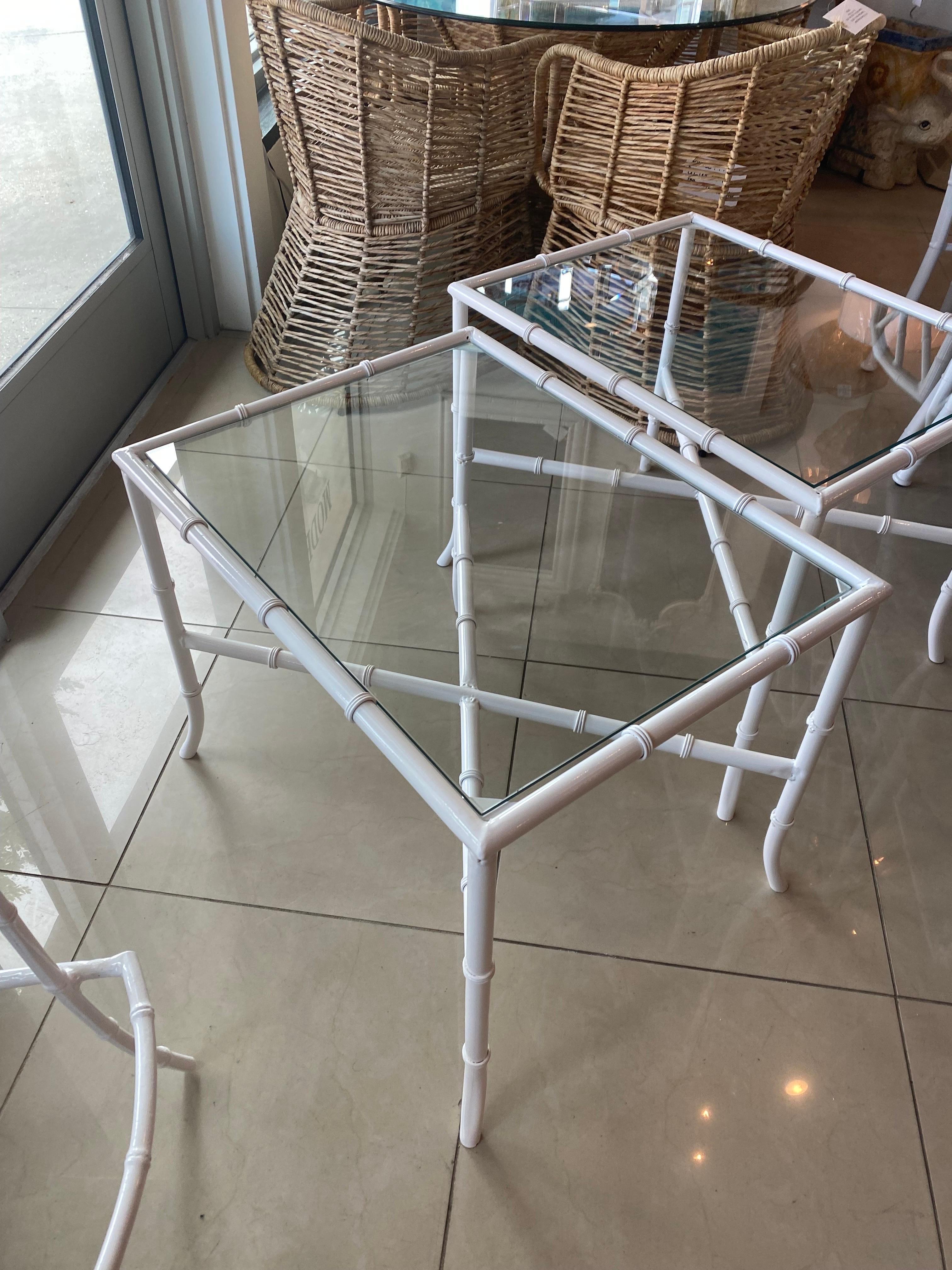 Vintage pair of metal, faux bamboo indoor outdoor side end tables. These have been newly powder-coated in white with new glass tops. Dimensions: 21 H x 20.5 W x 26.5 D.