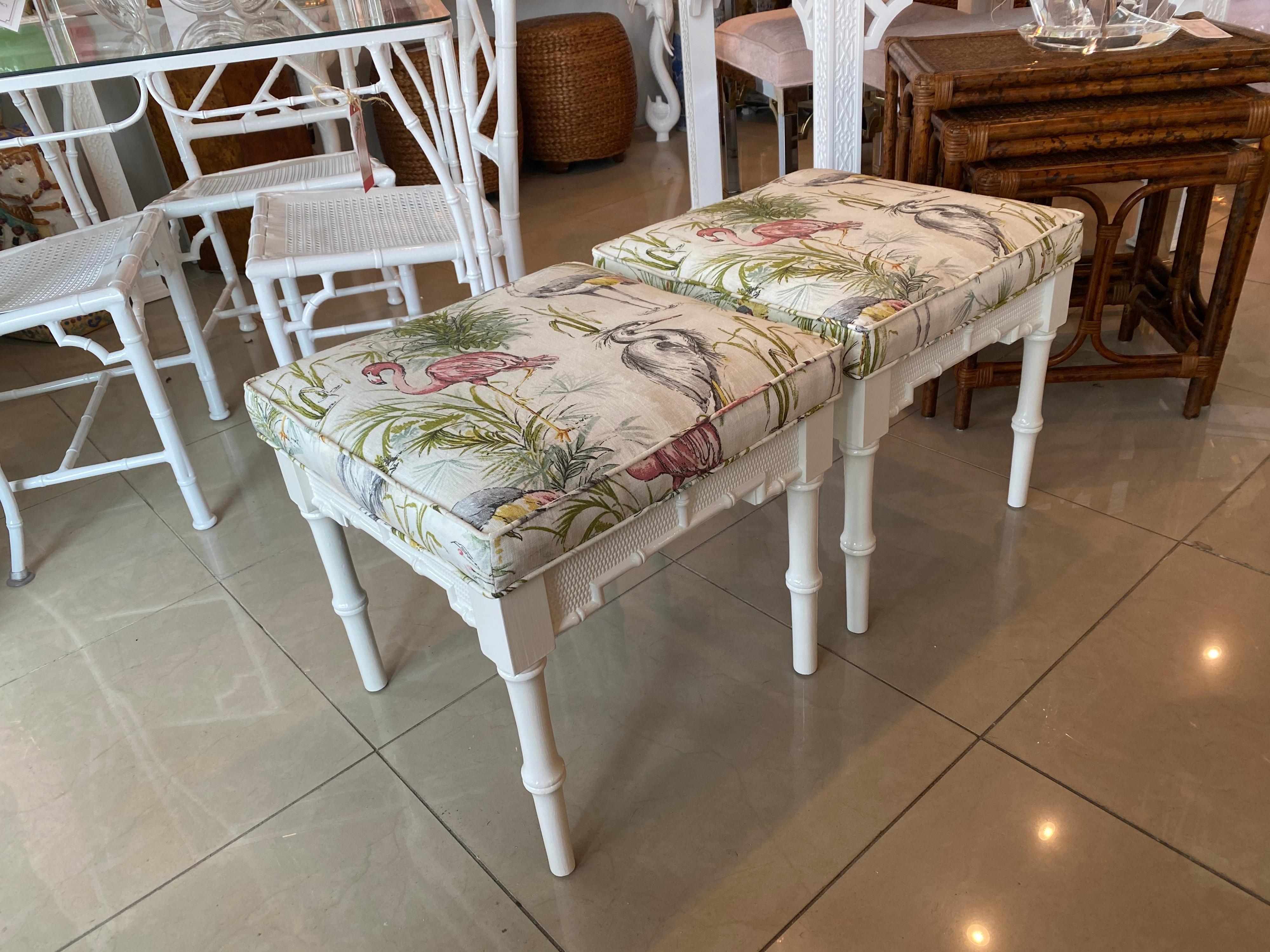 Pair of beautiful vintage, faux bamboo, stools benches. These have been newly lacquered in a soft white. Newly upholstered in a bird motif linen French fabric. The insides of the cushions are new also.