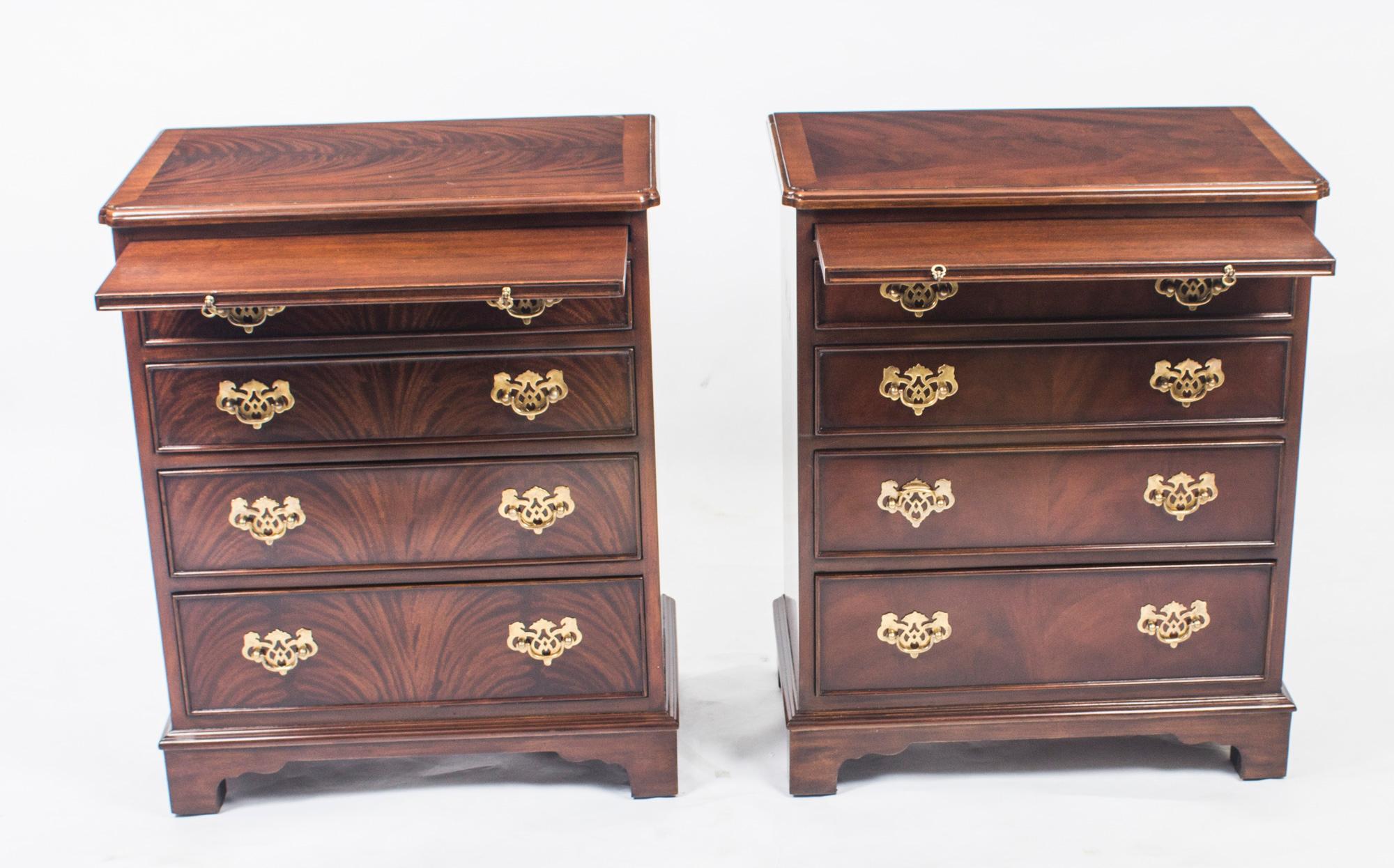 This is a beautiful pair of  flame mahogany chests with slides in elegant Georgian style dating from the late 20th Century.

The chests are masterfully crafted from gorgeous flame mahogany and the tops have superb crossbanded decoration. They each