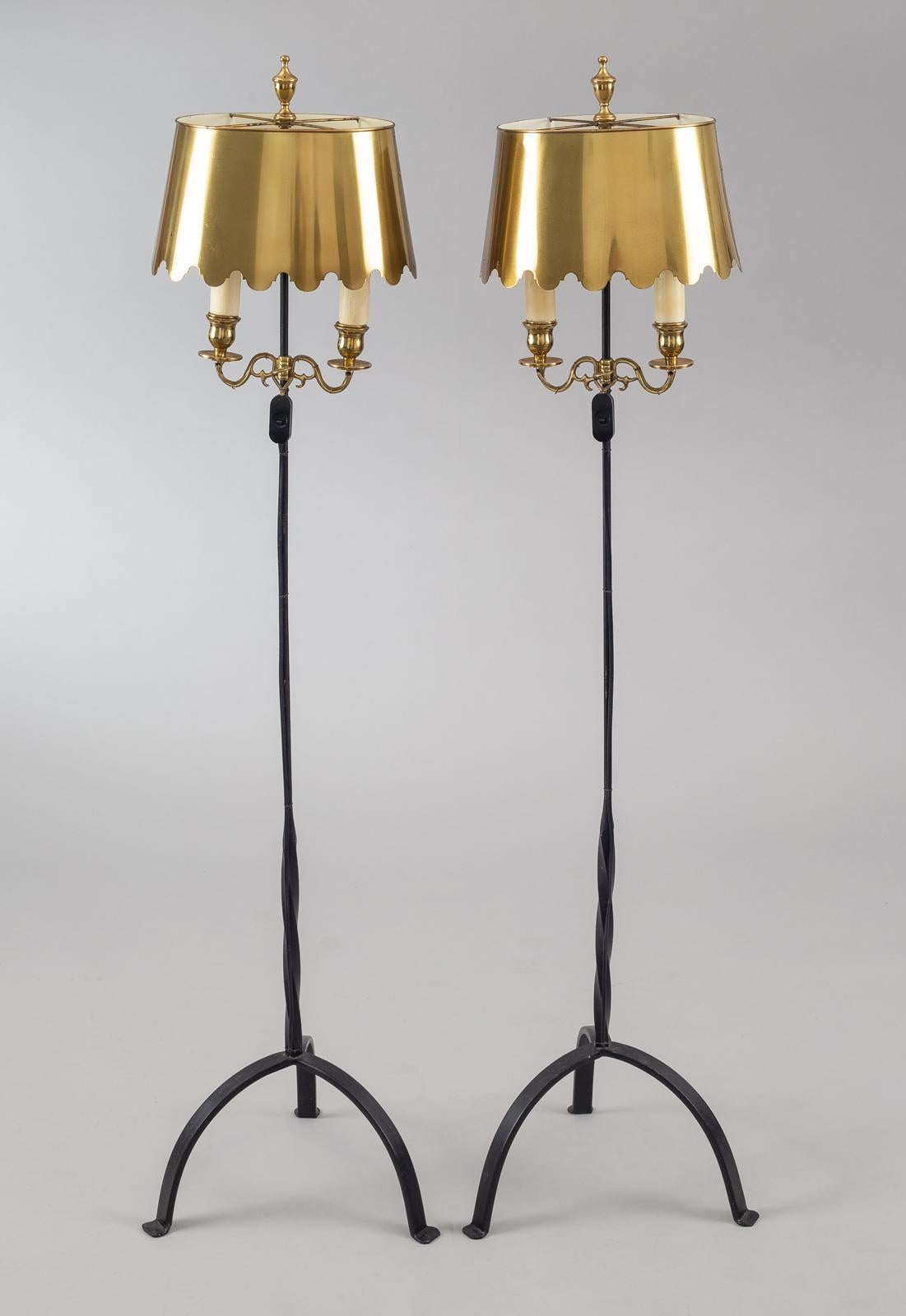Pair of vintage Fortuny floor lamps, the tripod pedestal bases are wrought iron and the oval-shaped scalloped shades are brass, as are the two candle arms and finials.