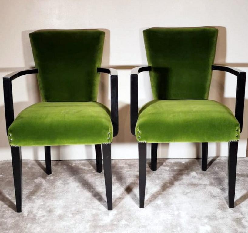 Elegant and seductive pair of French chairs; they are made with a sturdy black lacquered wood; the structure is very solid; the legs, compact and strong, have a slim and pleasant design; the arms are curved outward to give more space and comfort to