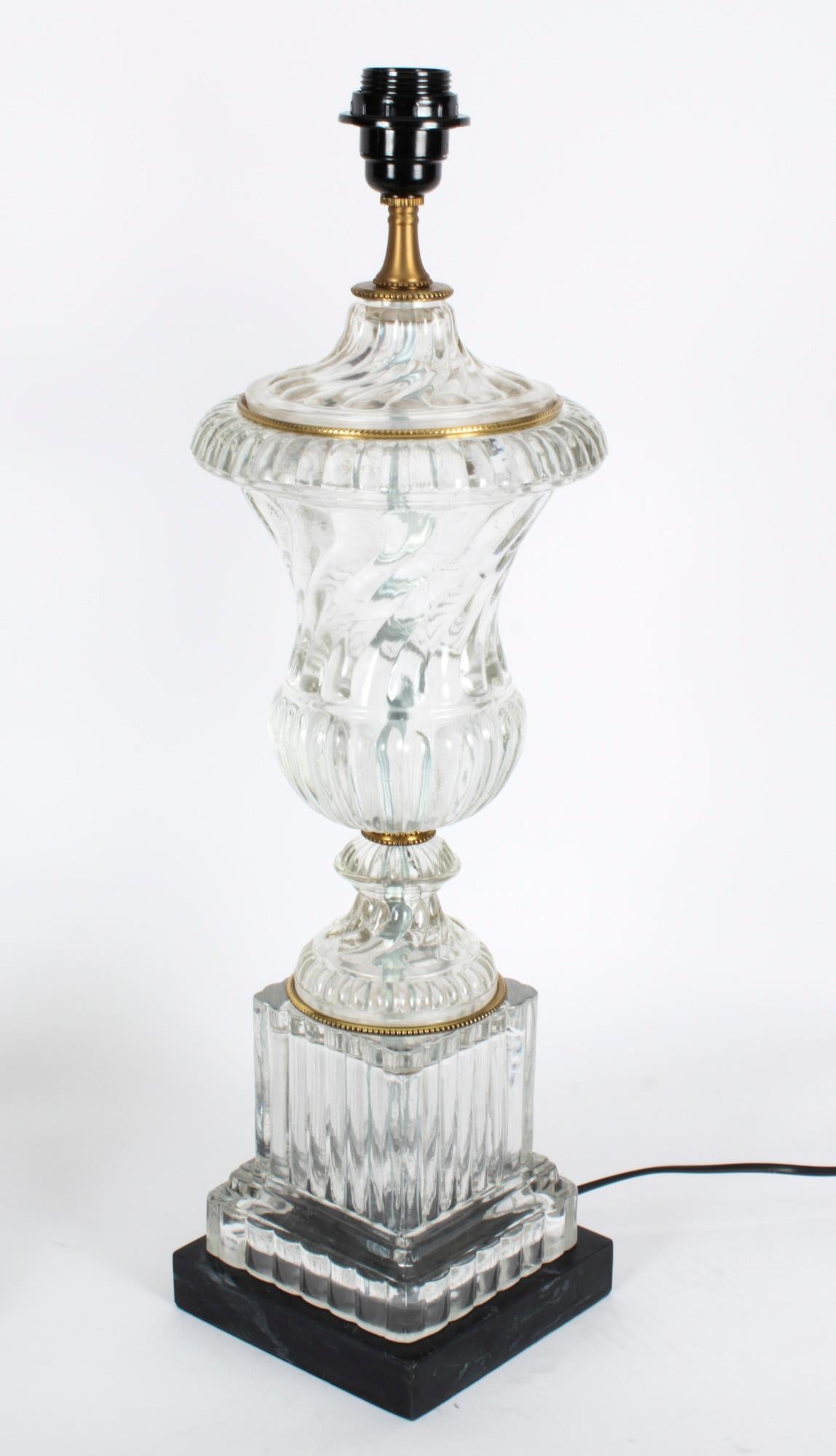 This is an elegant pair of vintage French ormolu and glass table lamps, late 20th century in date.

These elegant lamps have a sophisticated moulded glass body with splendid ormolu high-lights. The lamps in a classical Athenian urn form, decorated