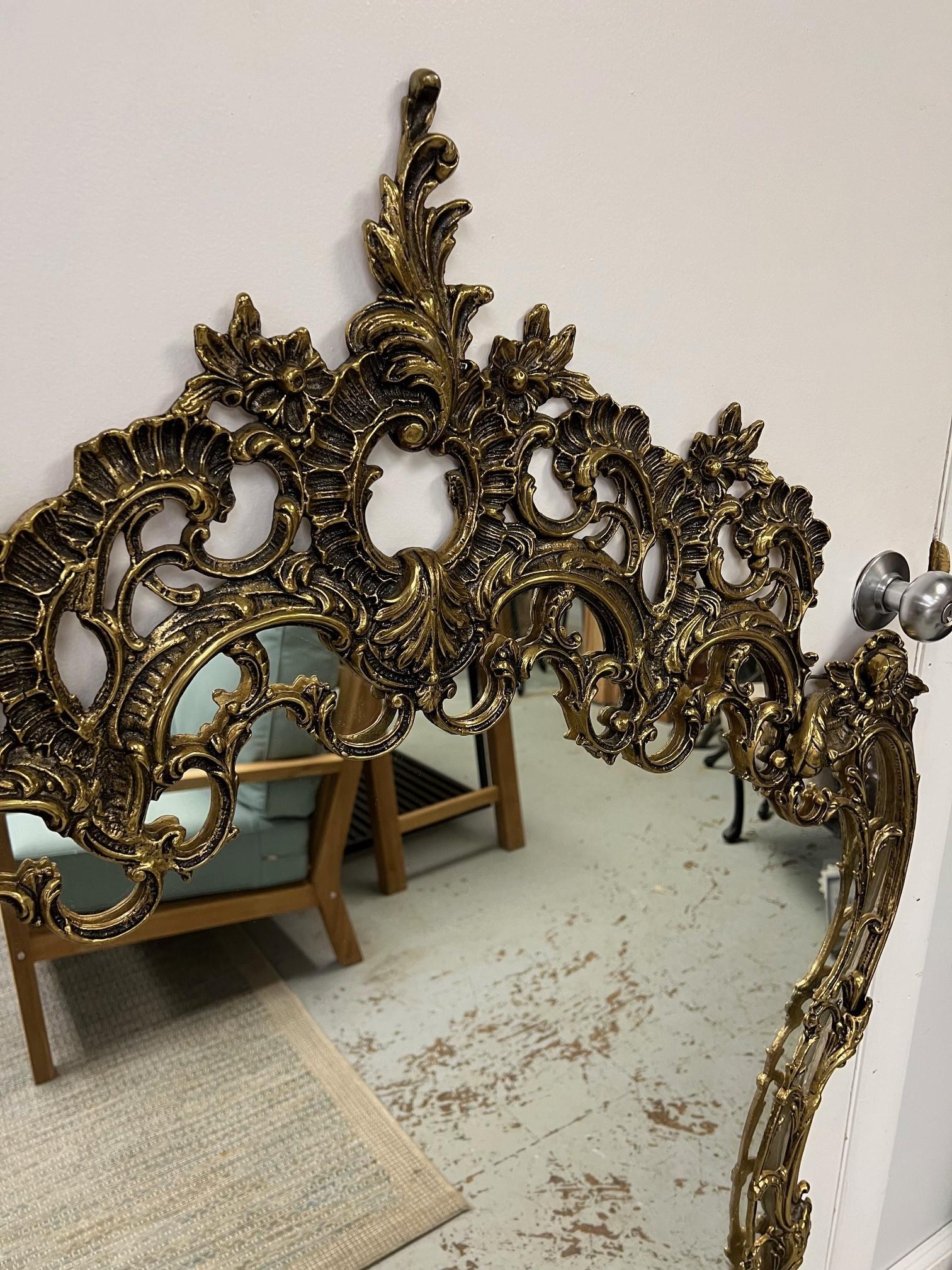 Solid brass pair of French Rococo style wall mirrors. Made in Europe possibly France late 40's early 50s in good condition. It's possible the mirrors and backs have been replaced years ago but the frames are original and in good condition.