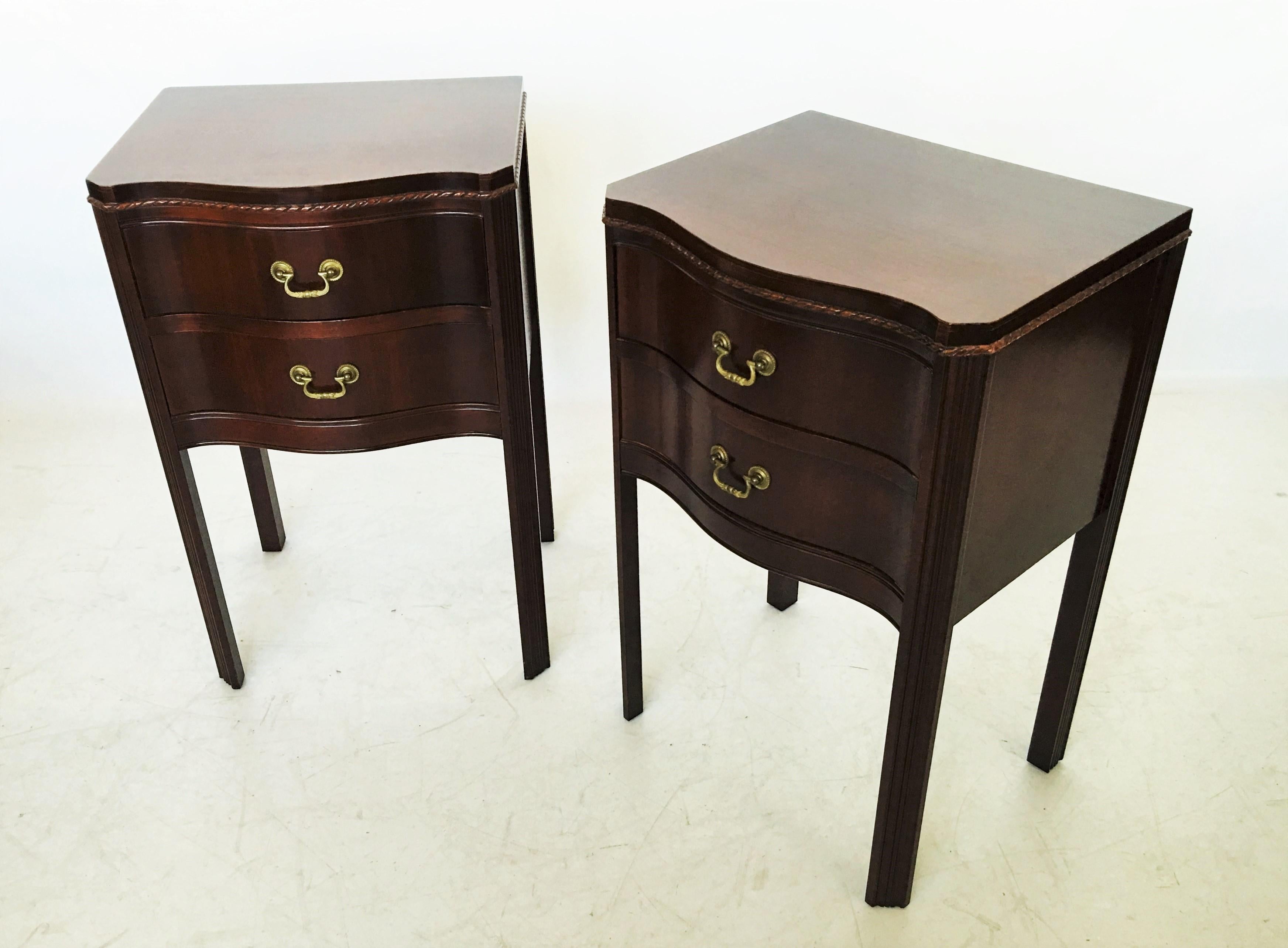 A fine pair of Georgian mahogany commodes made by the Wabash Cabinet Company in Wabash, Indiana circa 1940s. The tables are constructed from the finest quality mahogany wood. Featuring a serpentine front with a carved gadrooned top edge, two
