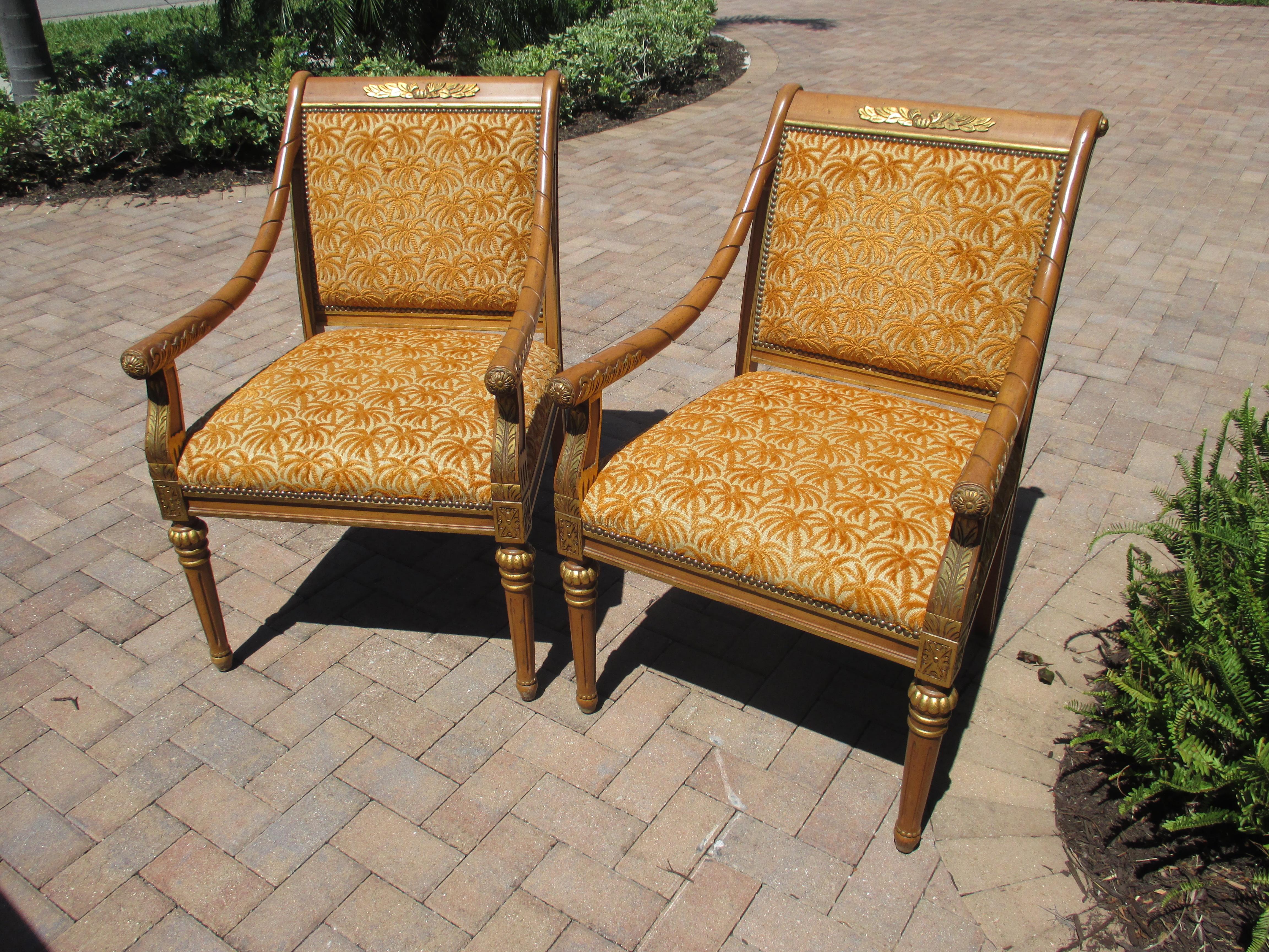 Magnifique paire de chaises Isenhour teintées miel avec des accents dorés, des sculptures et des garnitures en tête de clou. Les chaises sont recouvertes d'une tapisserie d'origine en forme de palmier orange brûlé en bon état. Les mesures de la