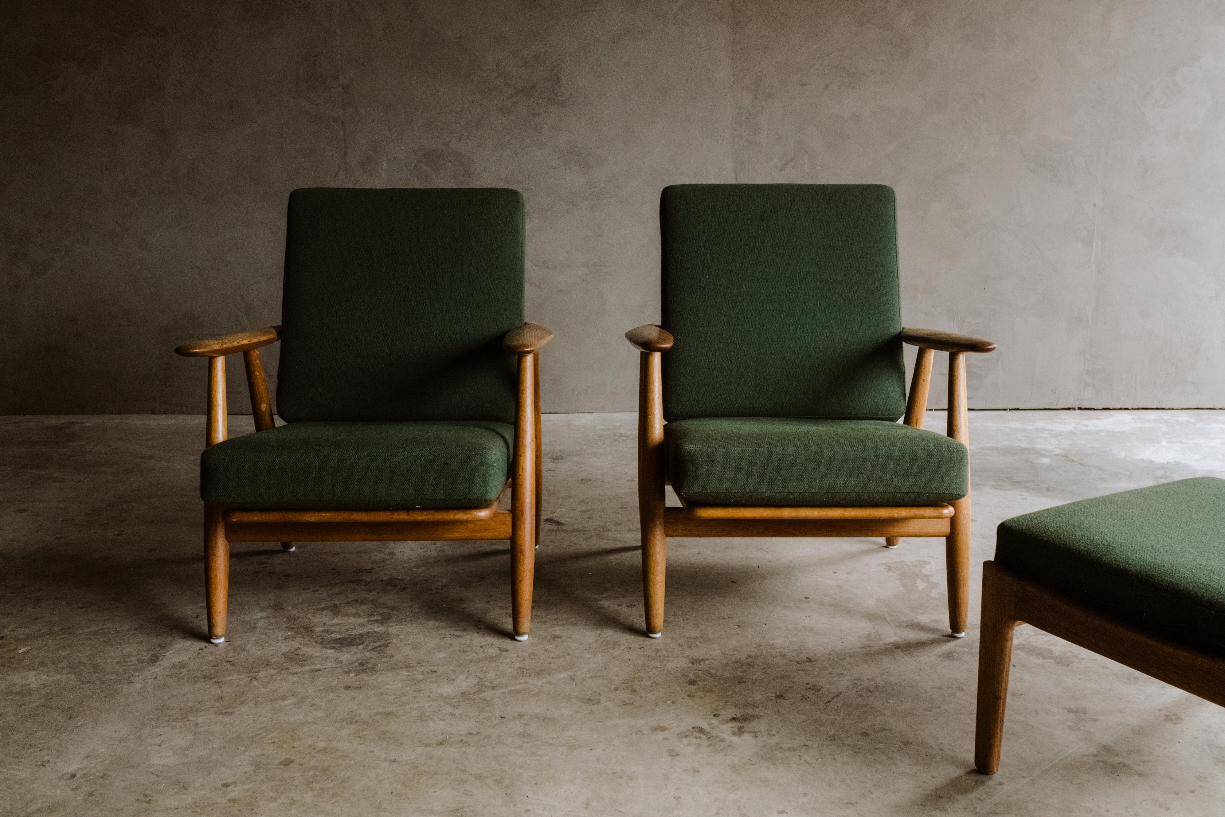 Vintage pair of Hans Wegner Cigar chairs with ottoman, Denmark 1960s. Solid oak frame with original green upholstered cushions. Light wear and patina.

We don't have the time to write an exhausting description on each of our pieces. We find it