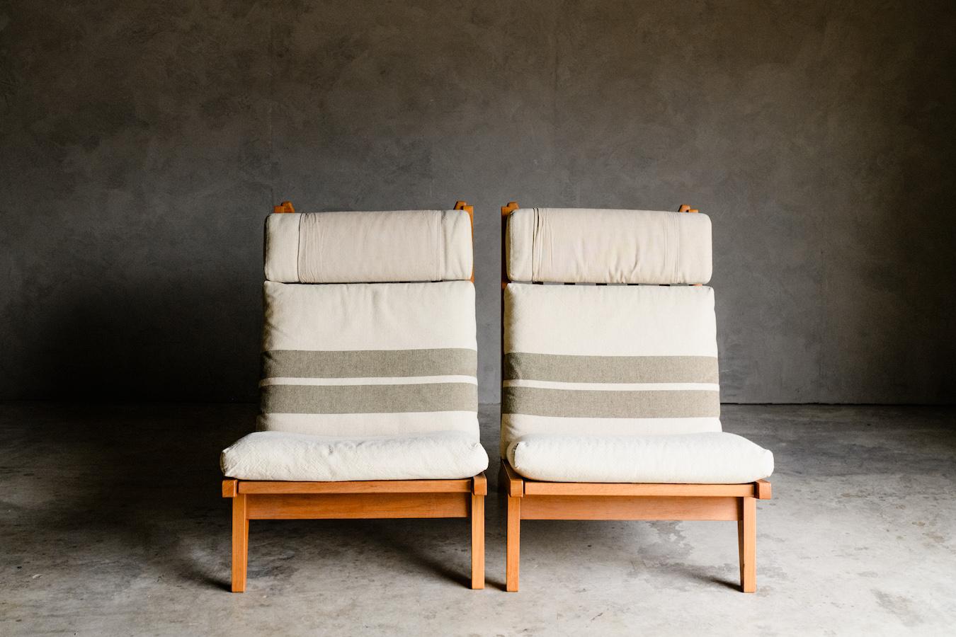 Vintage pair of Hans Wegner lounge chairs from Denmark, Circa 1960. Solid oak construction with cushions in a soft linen upholstery. Great condition with light ear and use. Model GE-375, made by GETAMA, Denmark.

 We don't have the time to write an