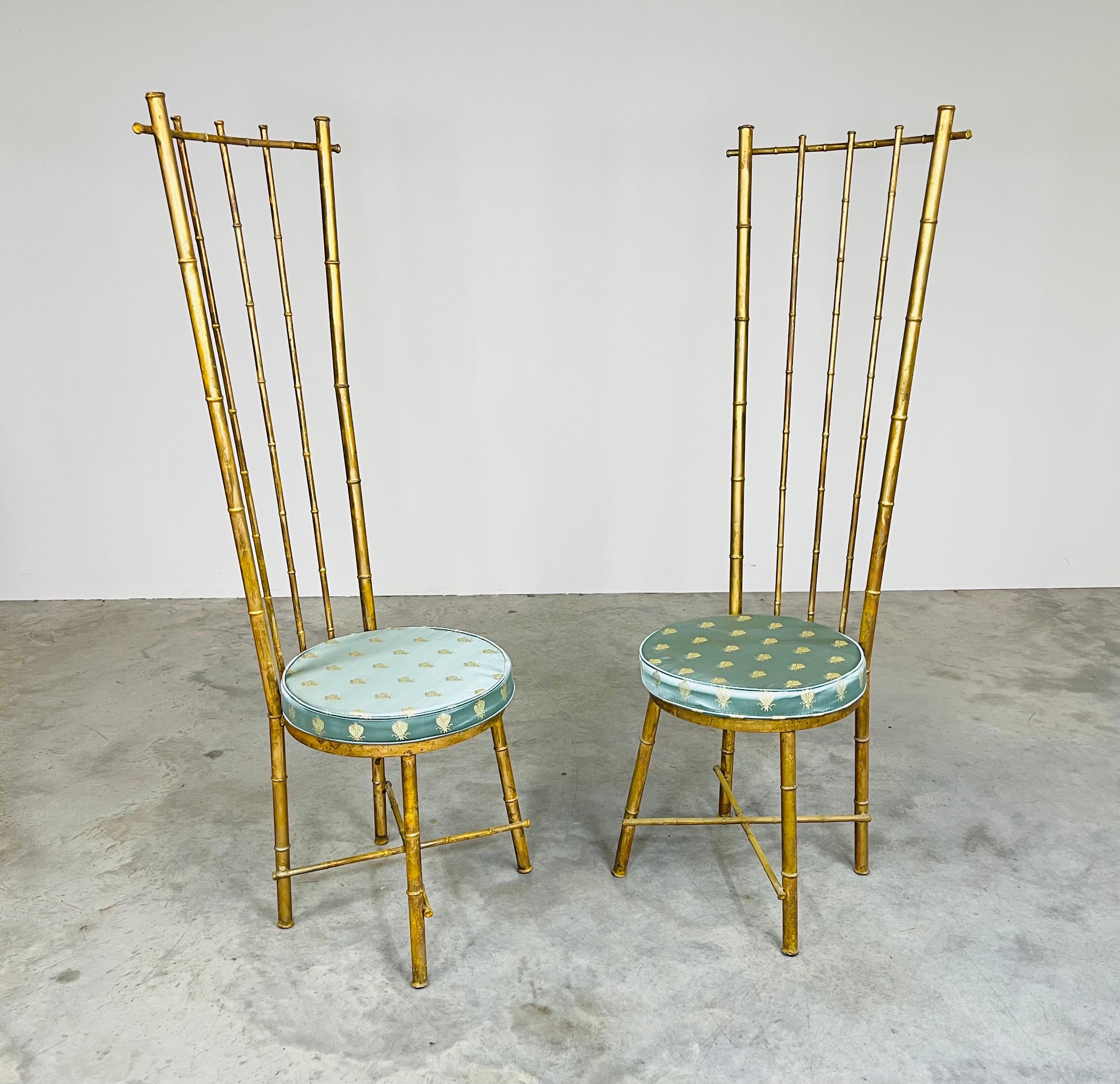 An elegant pair of Hollywood Regency gold gilt metal faux bamboo high-back accent chairs having silk bumblebee seat cushions. Very unique and playful in design. These attract attention in any setting and are quite comfortable as well. 
In very good