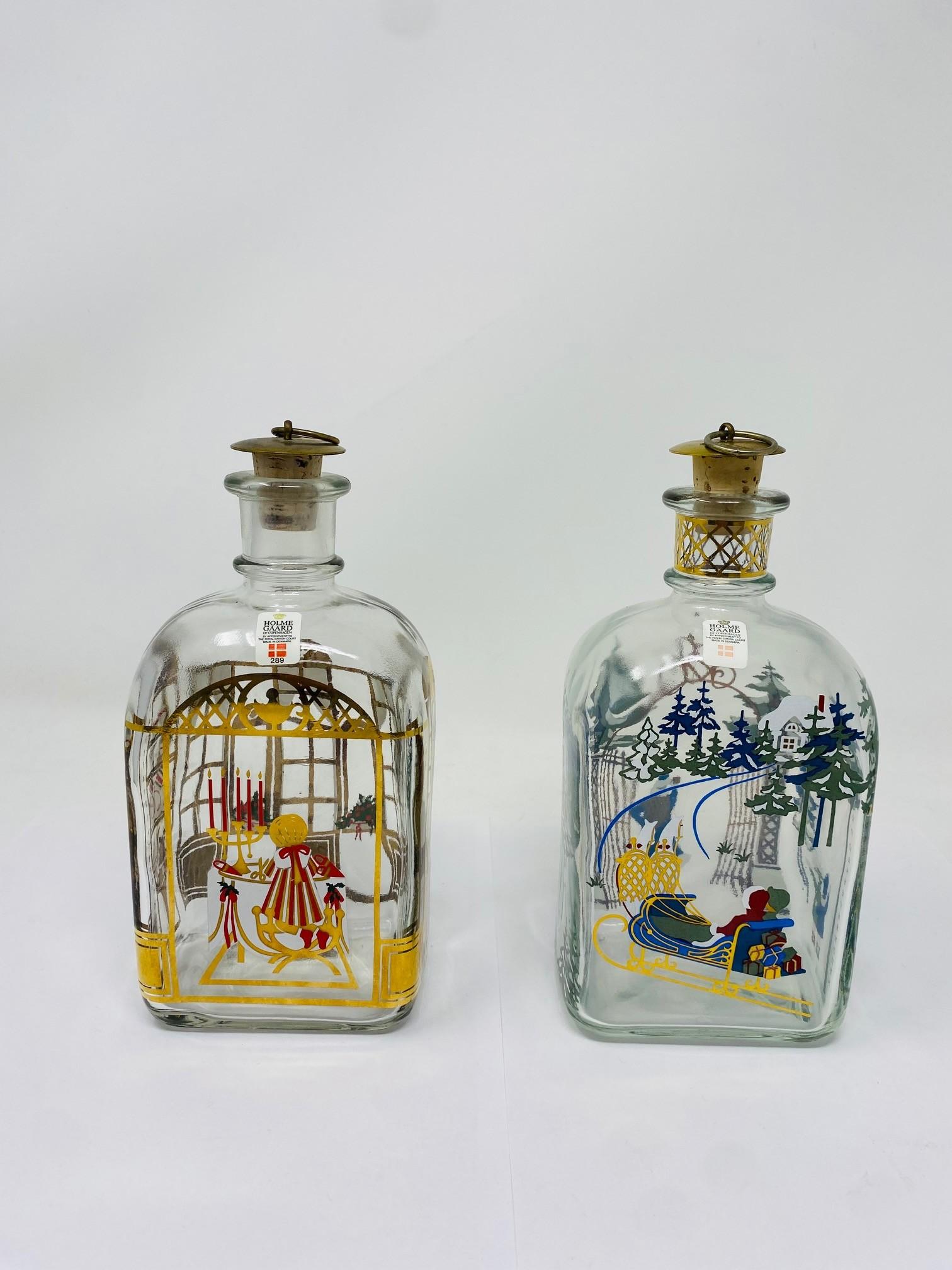 Edizioni festive del 1989 e del 1998 per Holmegaard.  Questi decantatori natalizi sono una tradizione per il noto produttore danese.  Sono pezzi da collezione e regali unici per gli appassionati di bar e Holmegaard.  Nuovo con le etichette