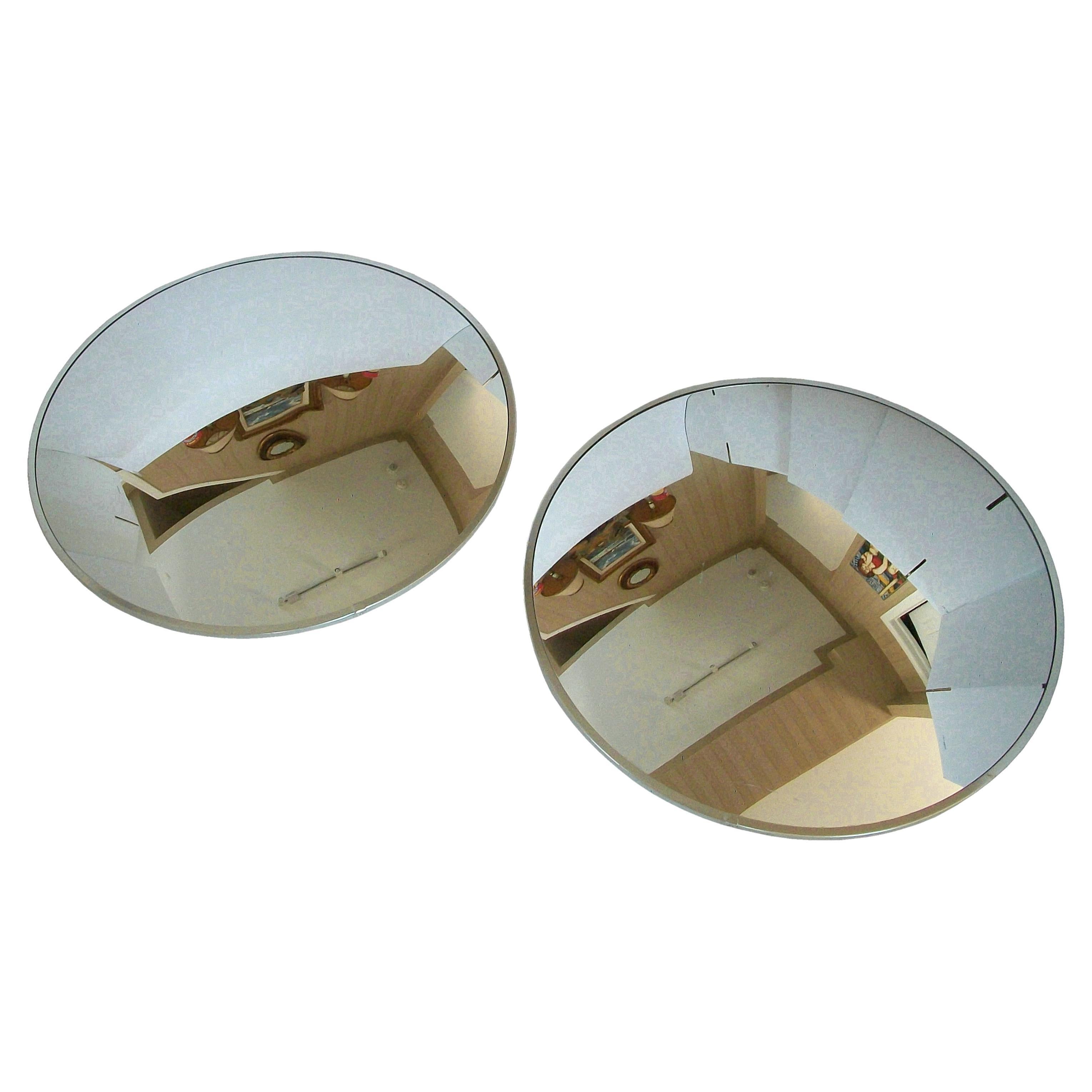 Vintage pair of industrial convex mirrors - aluminum metal trim - Masonite back panels - unsigned - United States - late 20th century.

Excellent vintage condition - scuffs and scratches to the mirror glass on both pieces - signs of age and