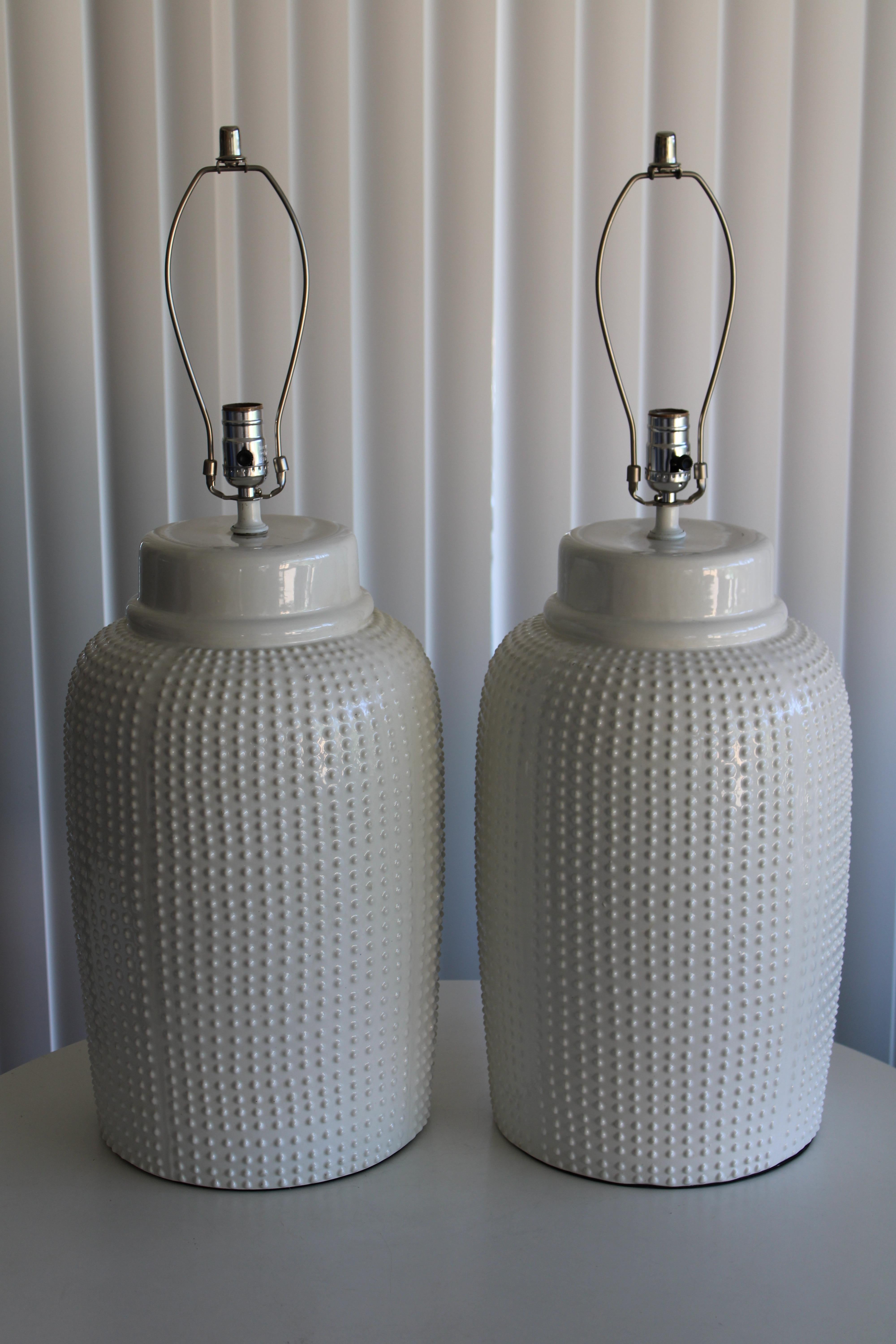 A matched pair of glazed ceramic table lamps with rows of raised dots running top to bottom. Lamps marked MADE IN ITALY on the bottom. Lamps have been professionally rewired. Ceramic portions alone measure: 20
