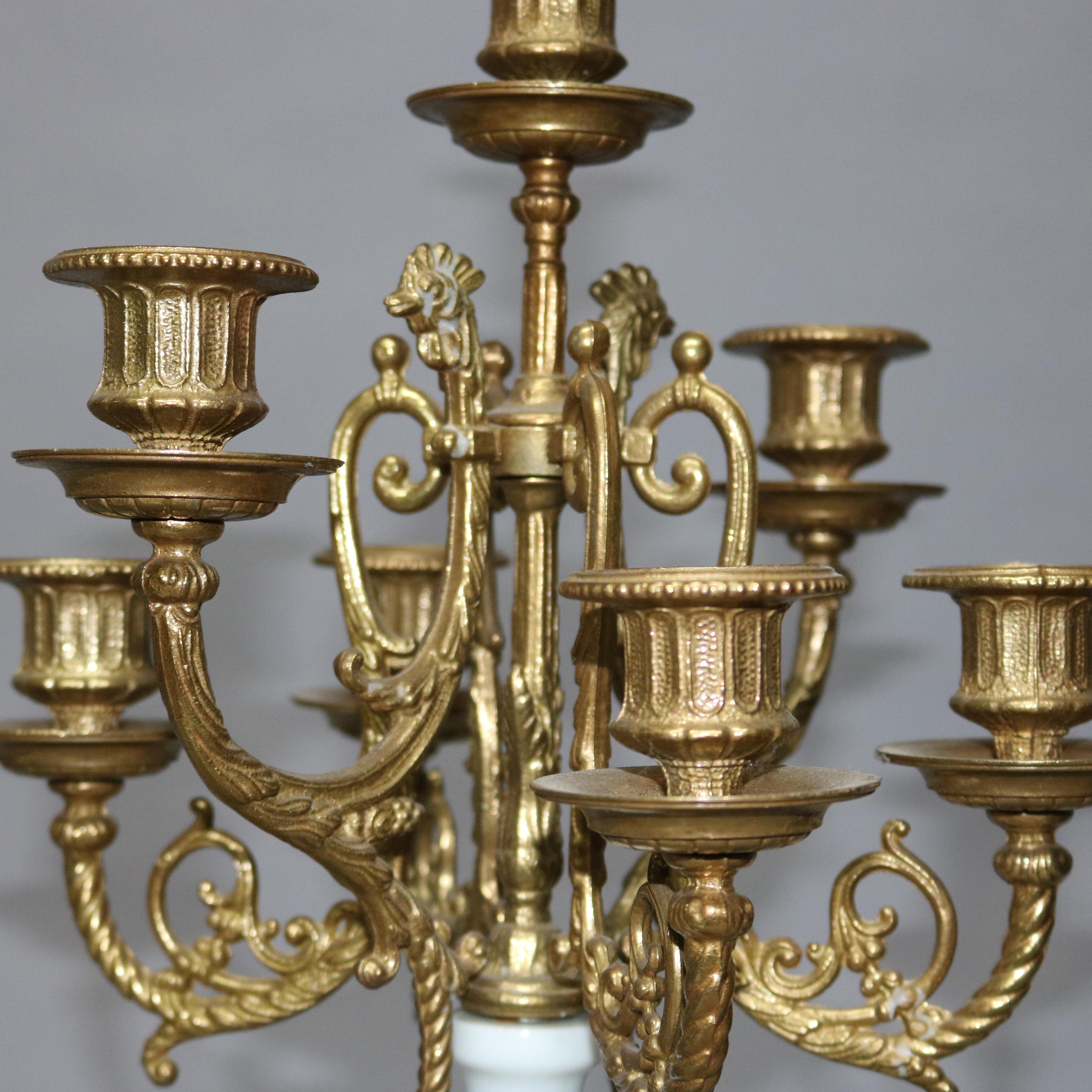 A vintage pair of Italian figural candelabra by Brevettato offers scroll and foliate form gilt metal arms terminating in candle sockets surmounting porcelain urn form column with classical cherub mounts, raised on marble plinth with cast claw foot