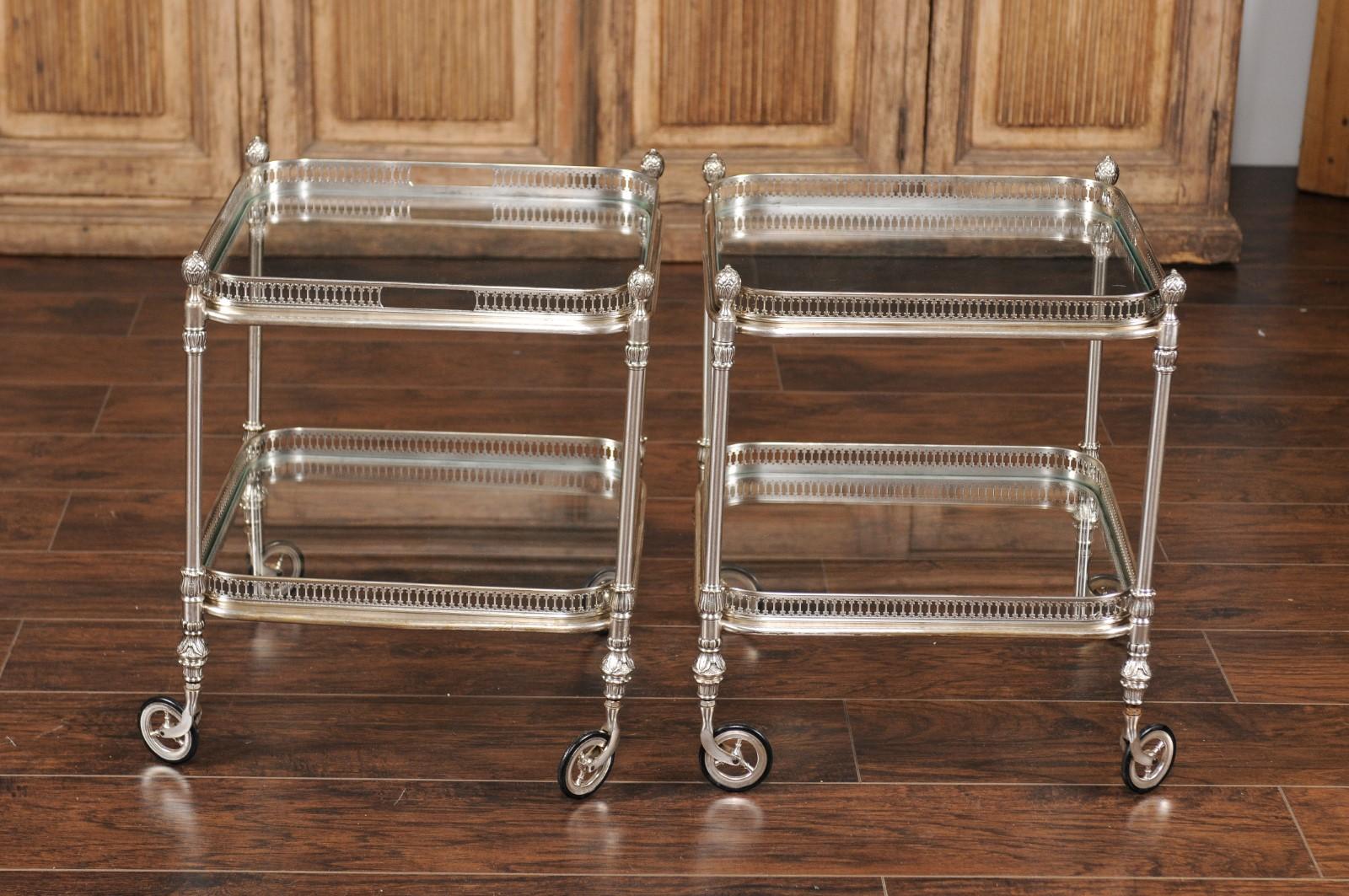 A pair of Italian vintage silvered and glass two-tiered trolleys from the mid-20th century, with pierced galleries and large casters. Born in Italy during the midcentury period, each of this pair of trolleys features a beautifully silvered