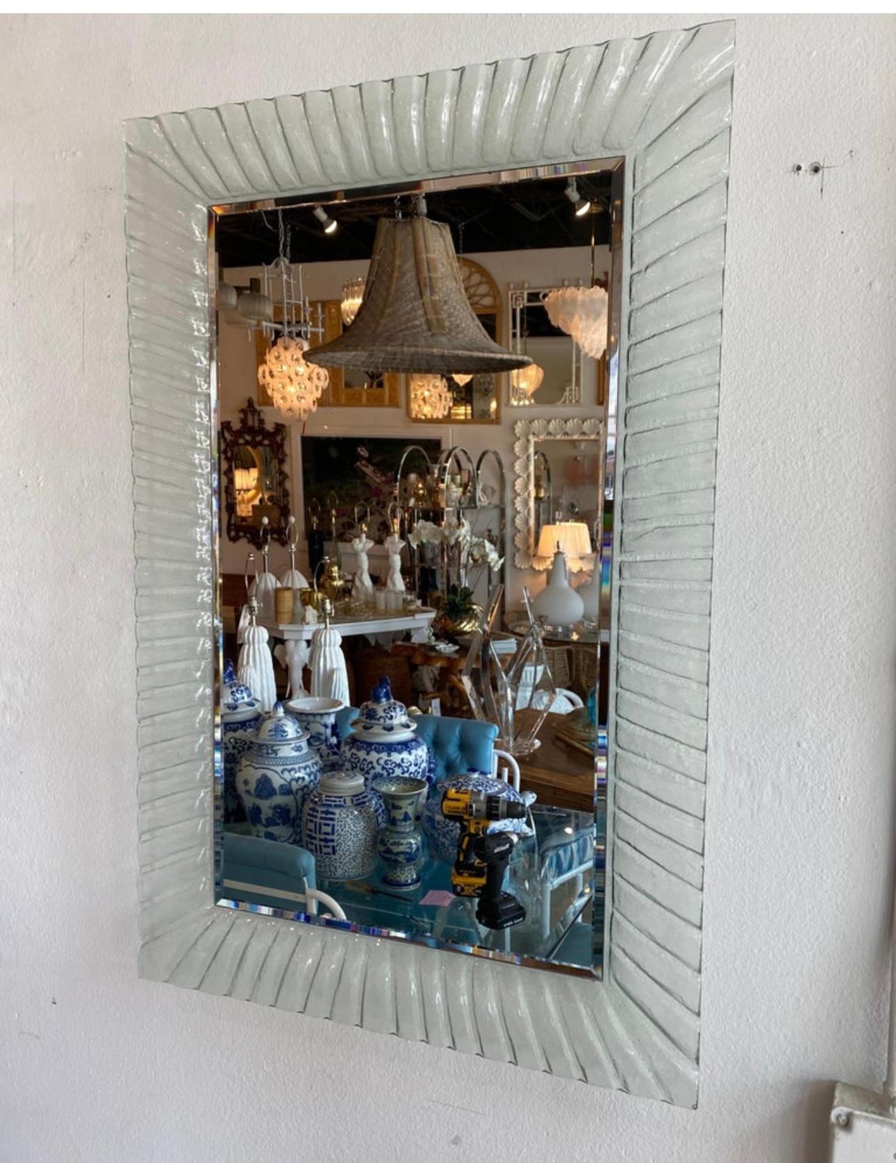 Lovely pair of vintage Murano glass mirrors. No chips or breaks to the glass. The entire mirror, including the back, is one piece of glass. This comes with a French cleat to mount both mirrors. The sides are wavy and have such a beautiful shape to