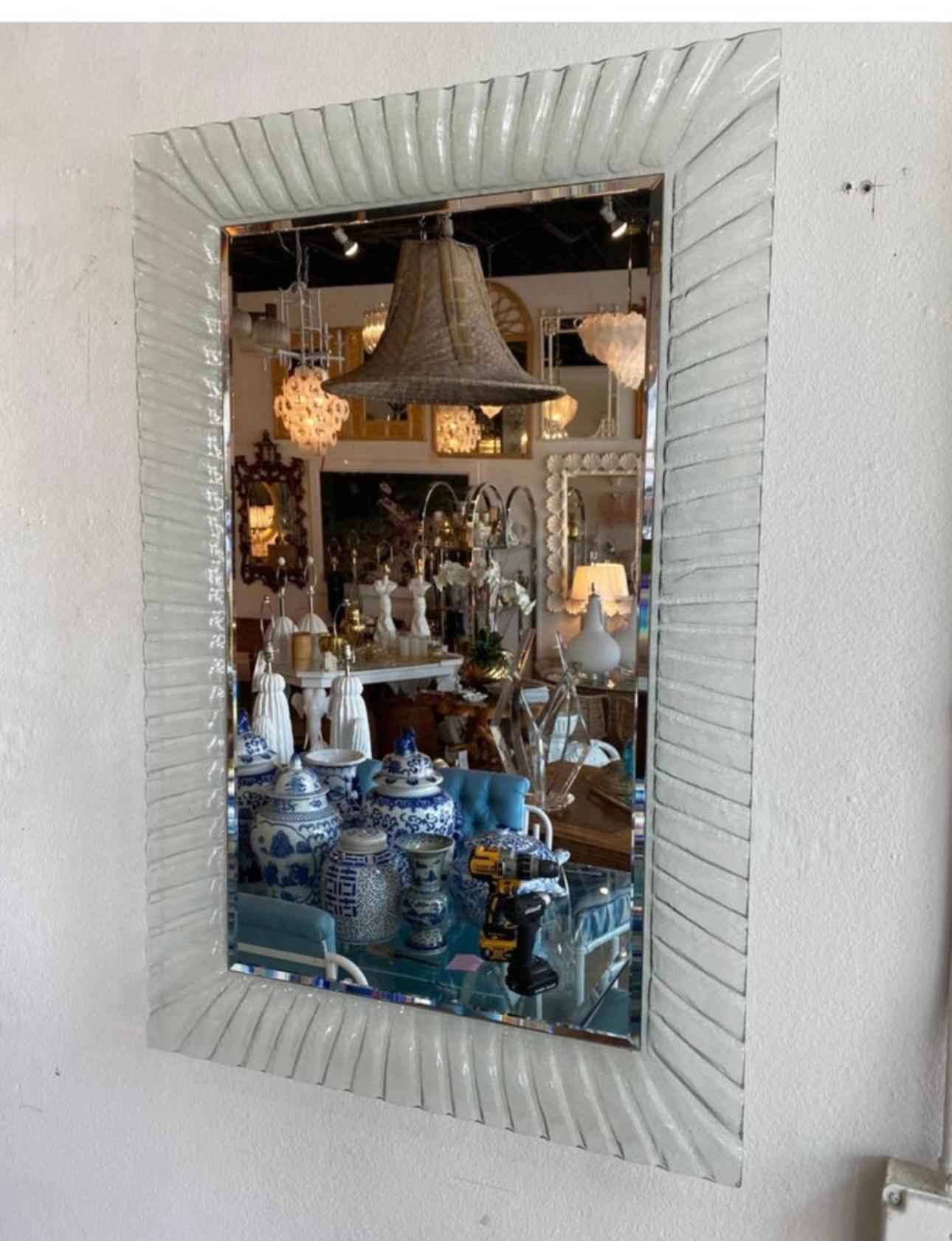 Lovely pair of vintage Murano glass mirrors. No chips or breaks to the glass. The entire mirror, including the back, is one piece of glass. This comes with a French cleat to mount both mirrors. The sides are wavy and have such a beautiful shape to