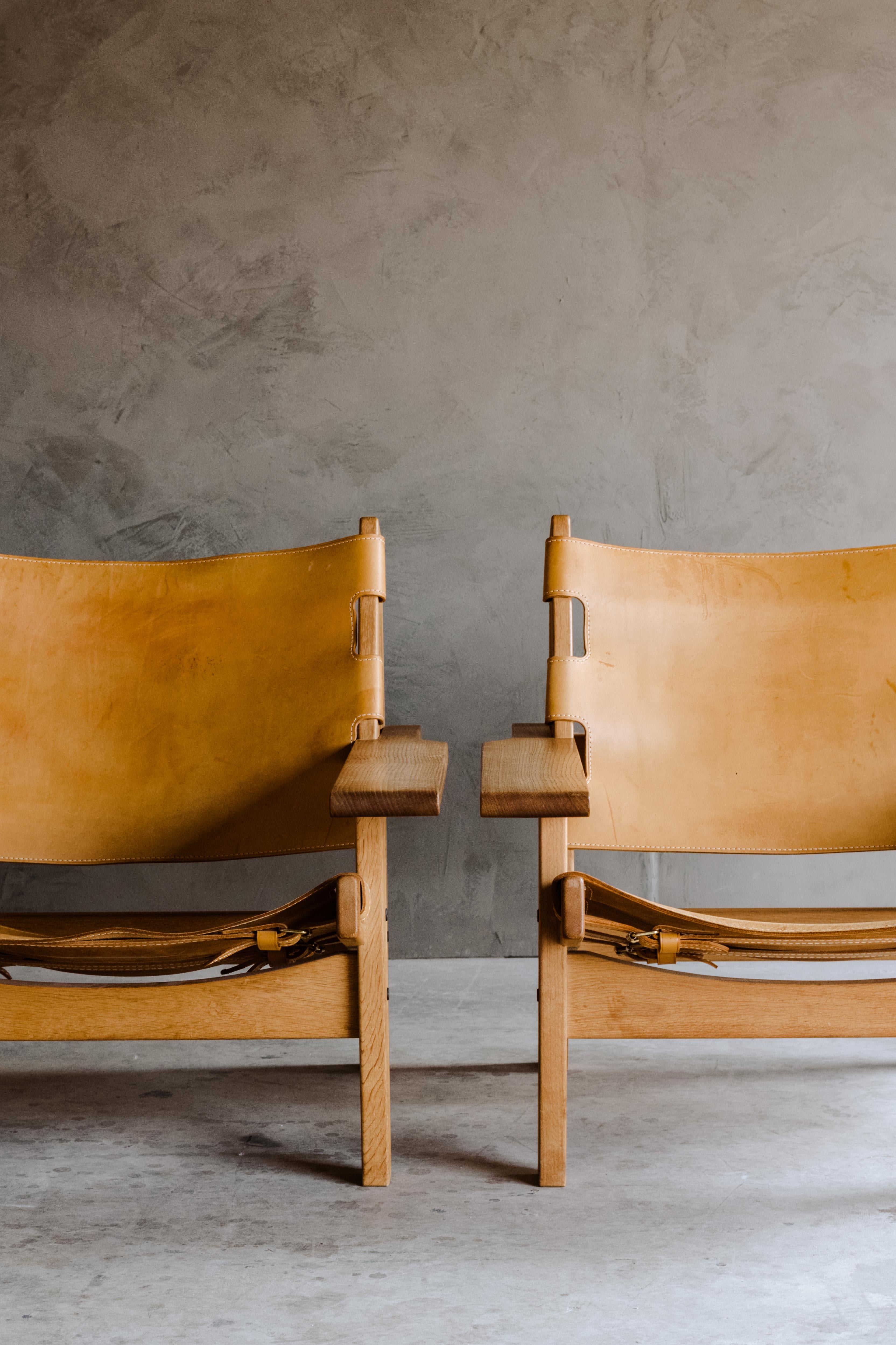 Vintage pair of Kurt Østervig hunting chairs from Denmark, 1960s. Solid oak construction with thick saddle leather. Excellent condition and patina.
