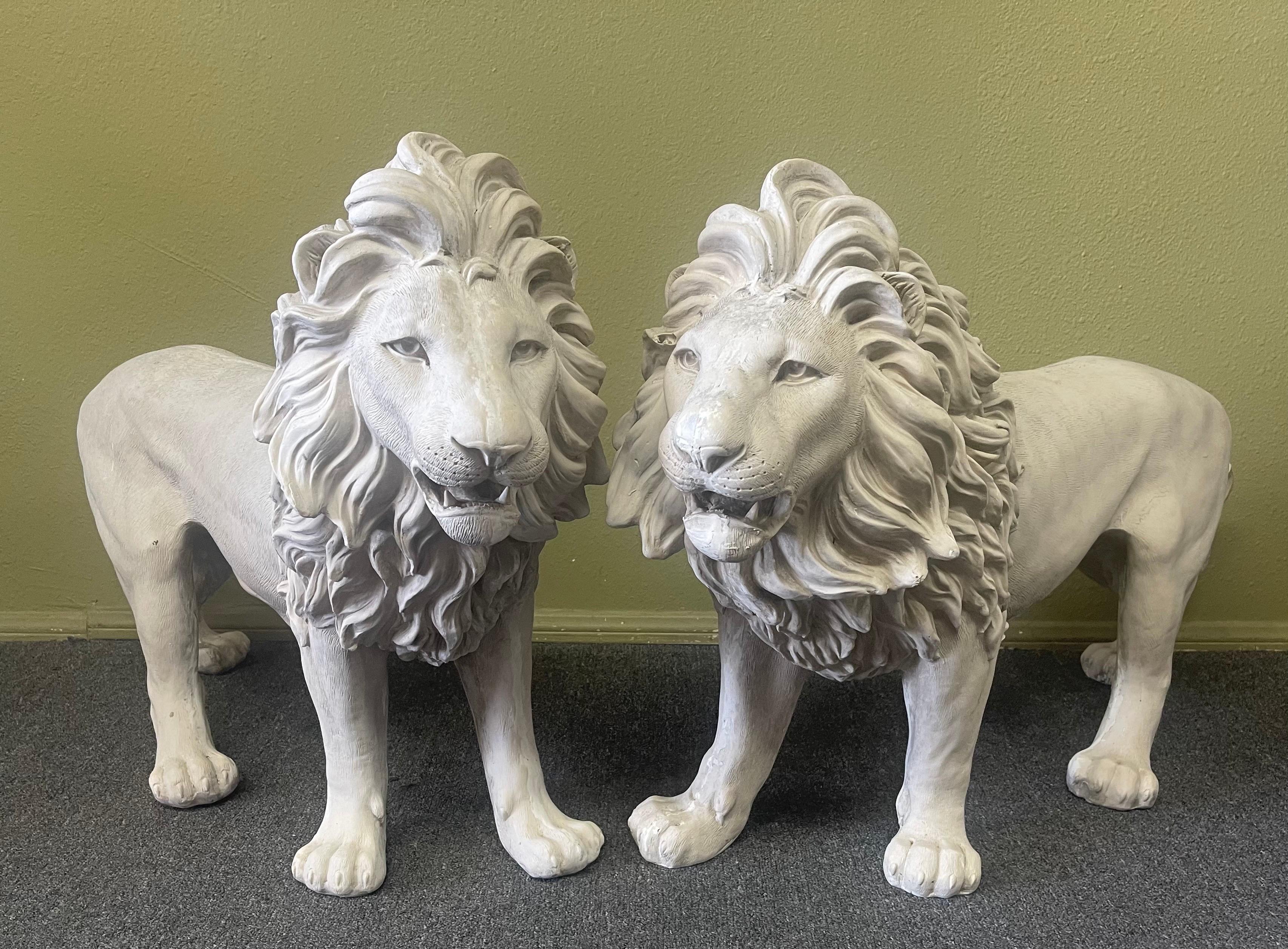 Super cool and hard to find vintage pair of large fiberglass lions, circa 1980s. The pair look like cast cement, but are made of lightweight and durable fiberglass; they are in good vintage condition with a weathered patina and nice detail. The