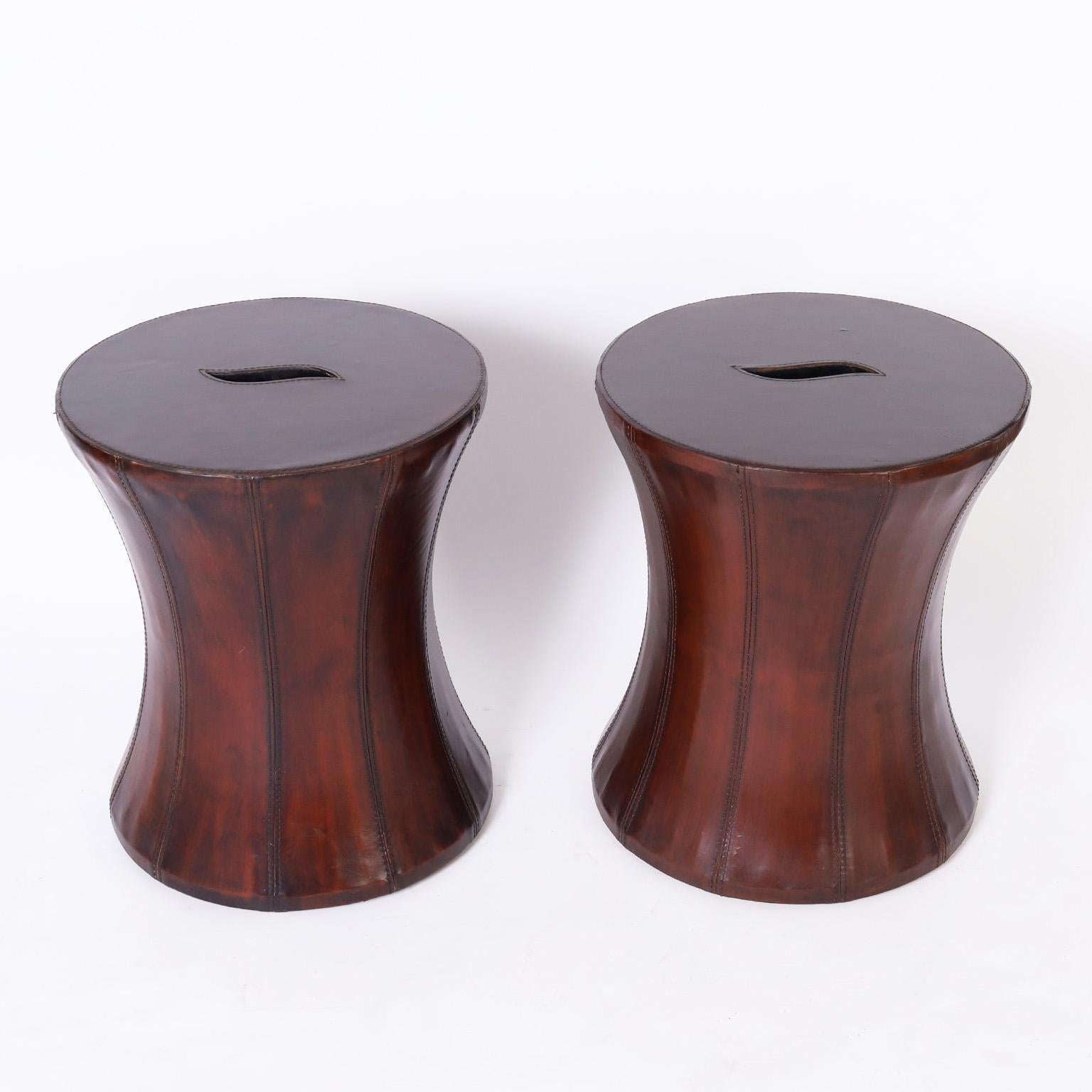 Unusual pair of seats or stands crafted with wood frames in a classic hourglass form and clad in lush brown leather.