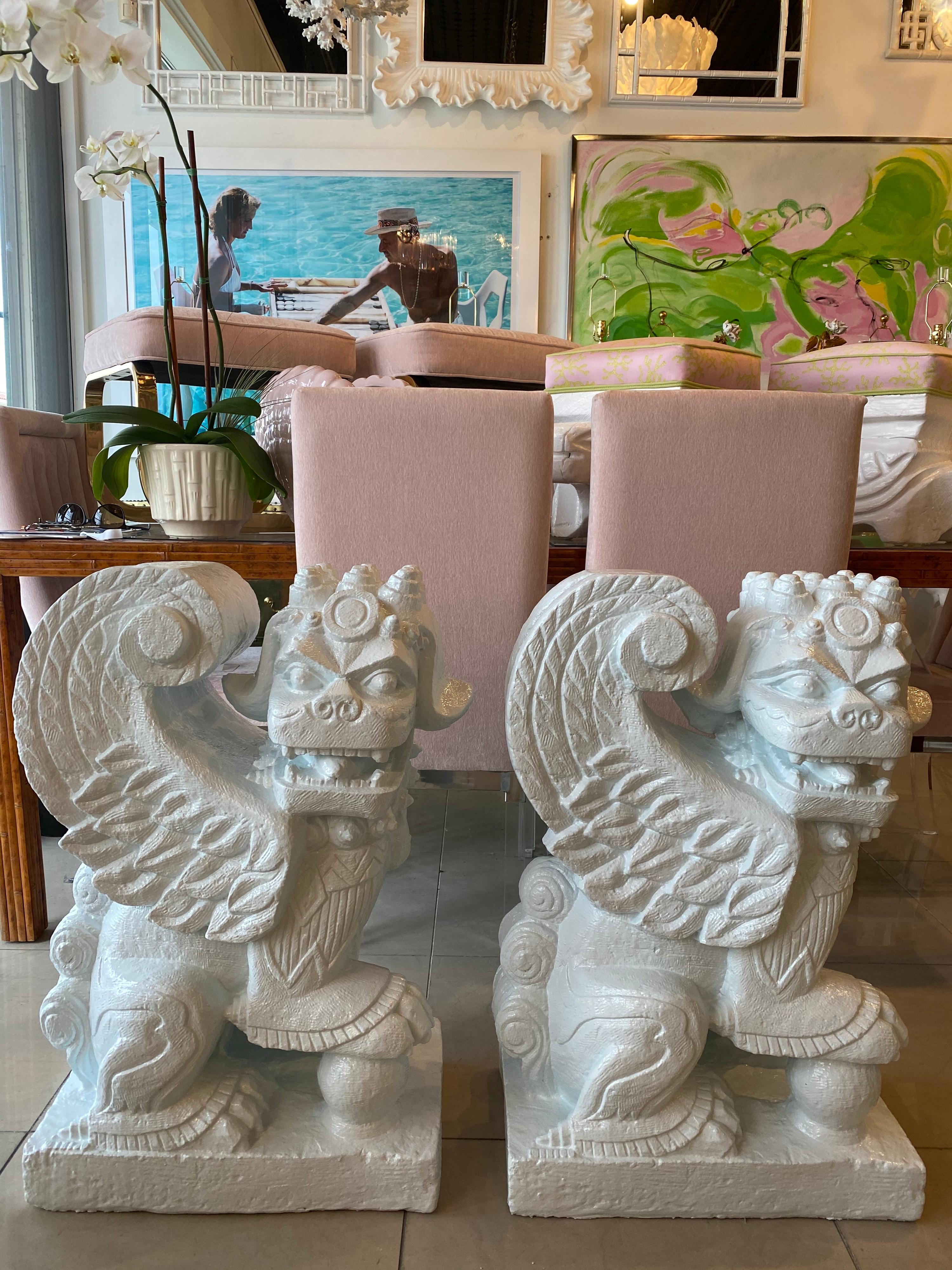 Vintage pair of plaster foo dogs in a very light blue lacquer. These are very heavy and can support a large piece of glass if needed. These can be used for a dining table base or a console table base.