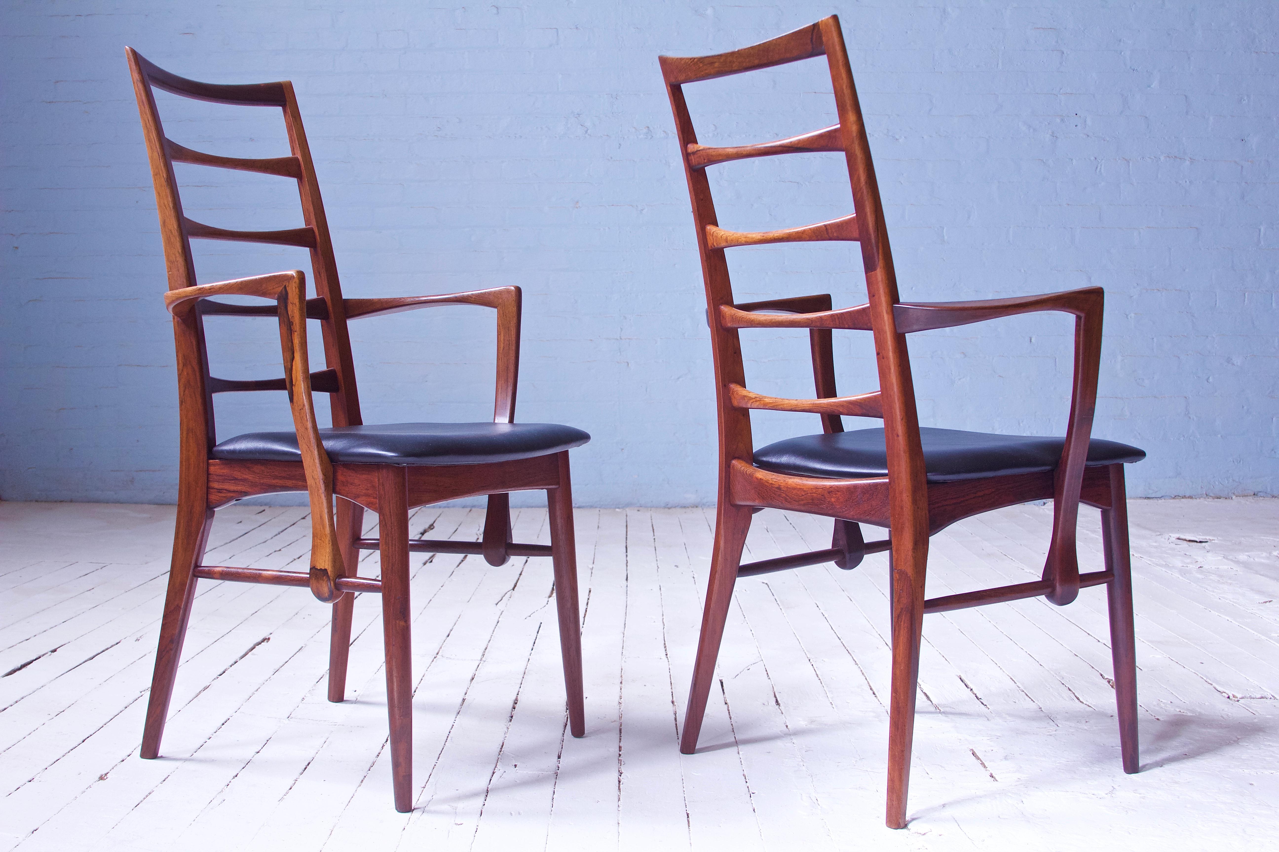 An awesome pair of the supremely elegant 'lis' armchairs in richly figured tropical hardwood and black leather. These frames feature a ladder back stile arrangement borrowed from various vernacular Windsor forms; here however the stiles are