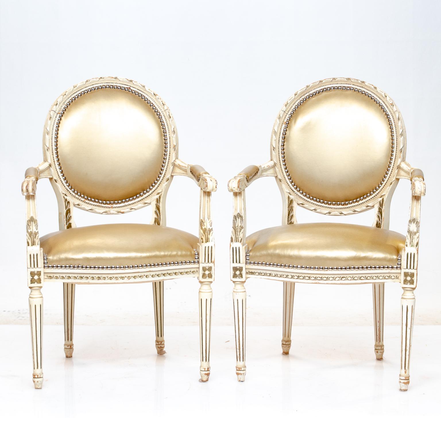 Vintage pair of Louis XVI armchairs
Louis XVI painted armchairs highlighted with gold accents and silver nailheads. Upholstery is fairly recent, good condition with a shinney gold look. Very sound condition.