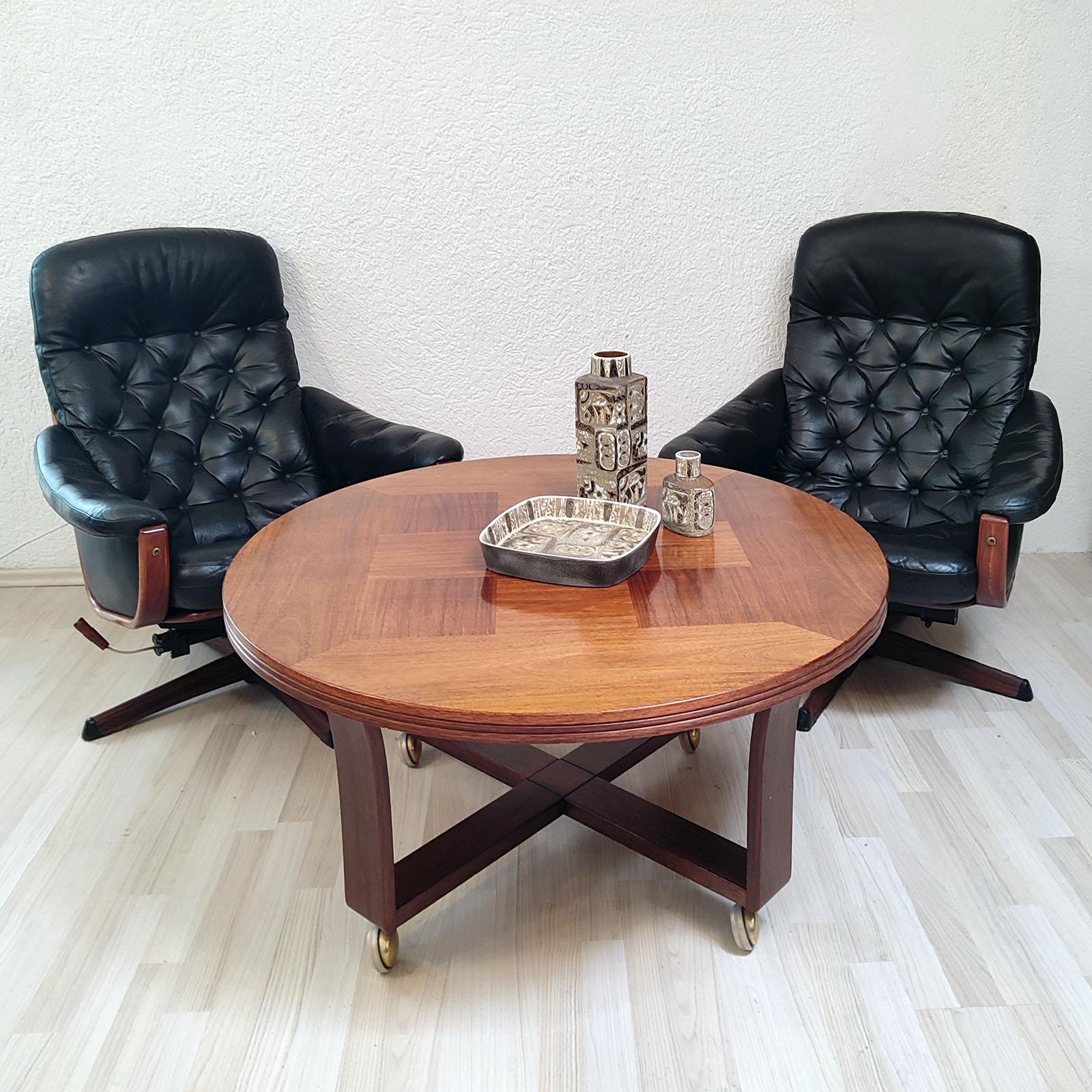 Very comfortable swivel armchairs by Göte Möbel Nassjo from Sweden with adjustable backrest. Curved wooden frame with black leather padded upholstery. Metal star base with a wood pattern application. Good vintage condition. Leather is in good over