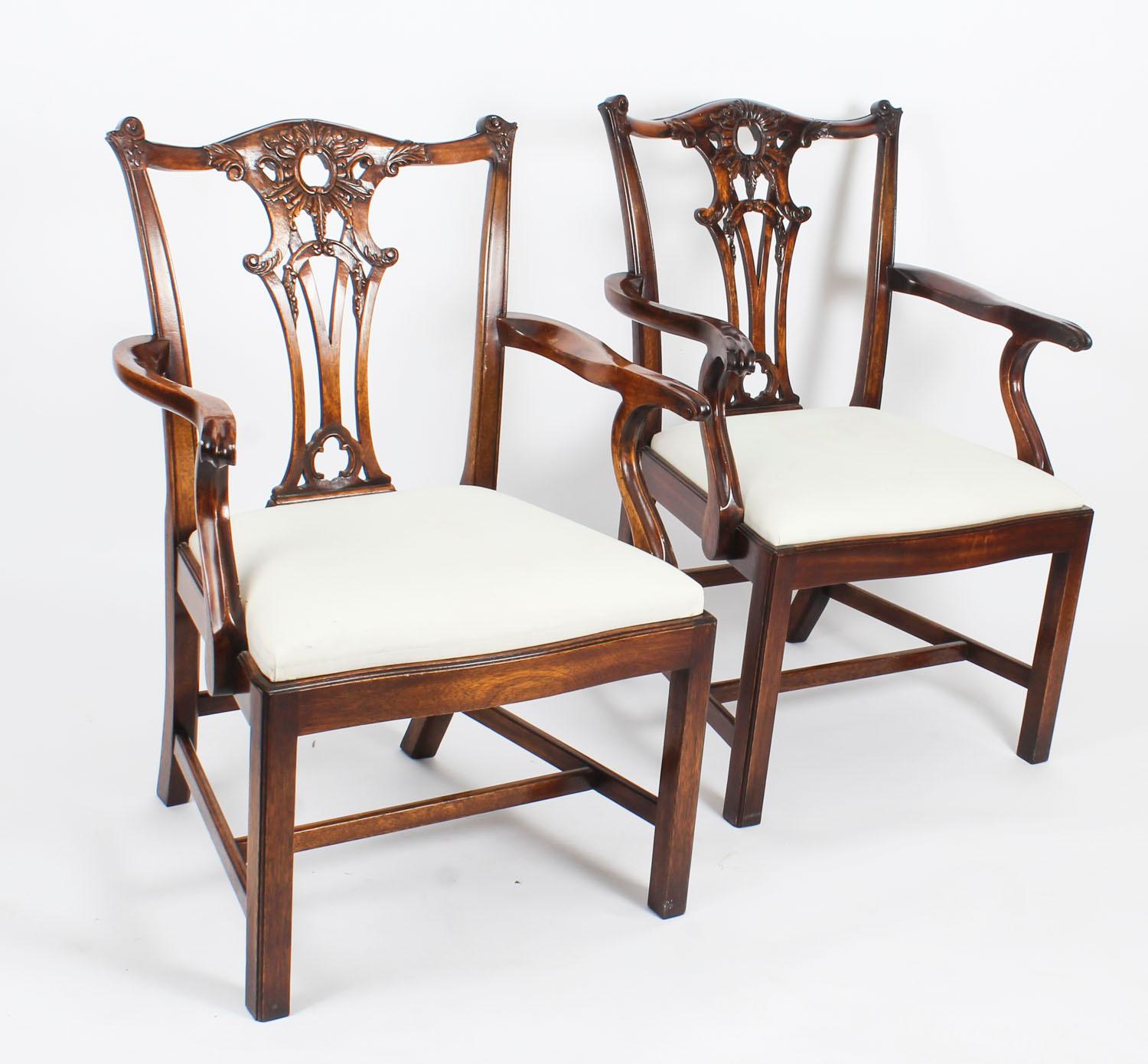 A beautiful vintage pair of Chippendale Revival carved mahogany open armchairs, dating from the mid-20th century.

They have been crafted from hand carved solid mahogany, each with a pierced splat back, drop in seats and raised on square cut