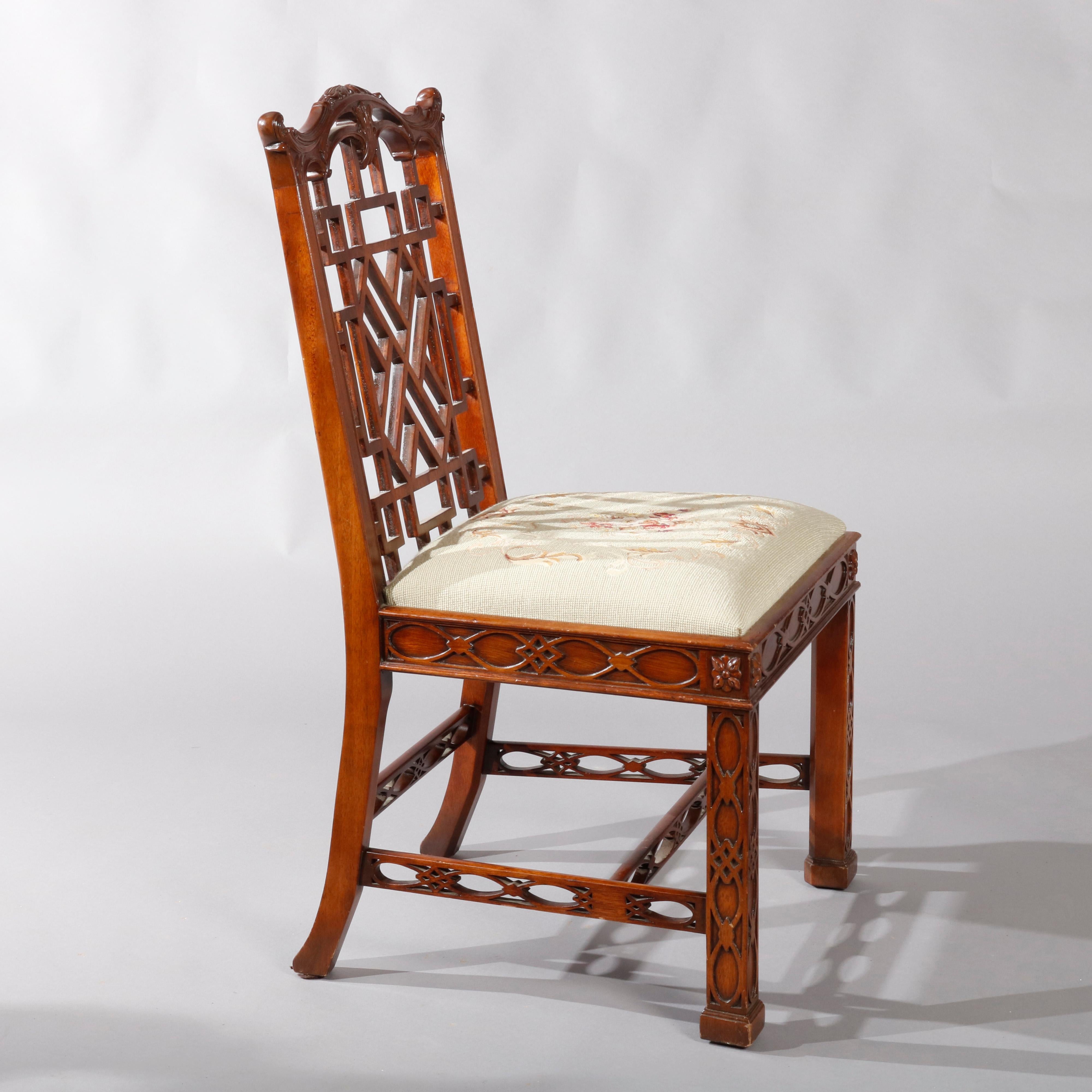 A vintage pair of Maitland Smith Chinese Chippendale style side chairs offer mahogany frame with foliate carved shaped crest surmounting lattice backs, floral needlepoint upholstered seats with carved frames and raised on straight square legs with