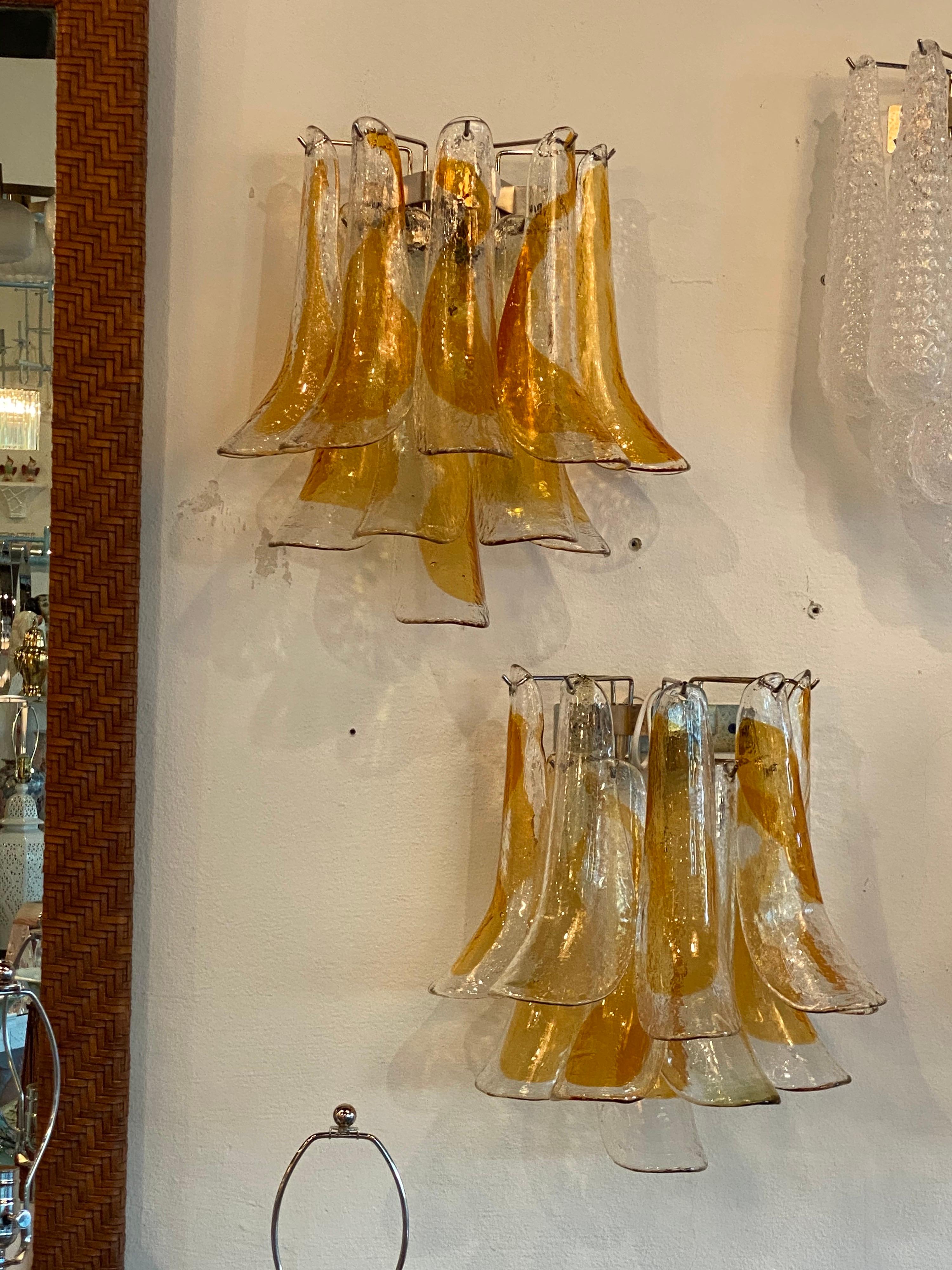 Beautiful pair of vintage amber & clear Murano Mazzega shoehorn feather glass wall light sconces. No chips or breaks to glass. Newly wired. Has 10 large pieces of glass per sconce. Holds 2 lightbulbs. Ready to hang.