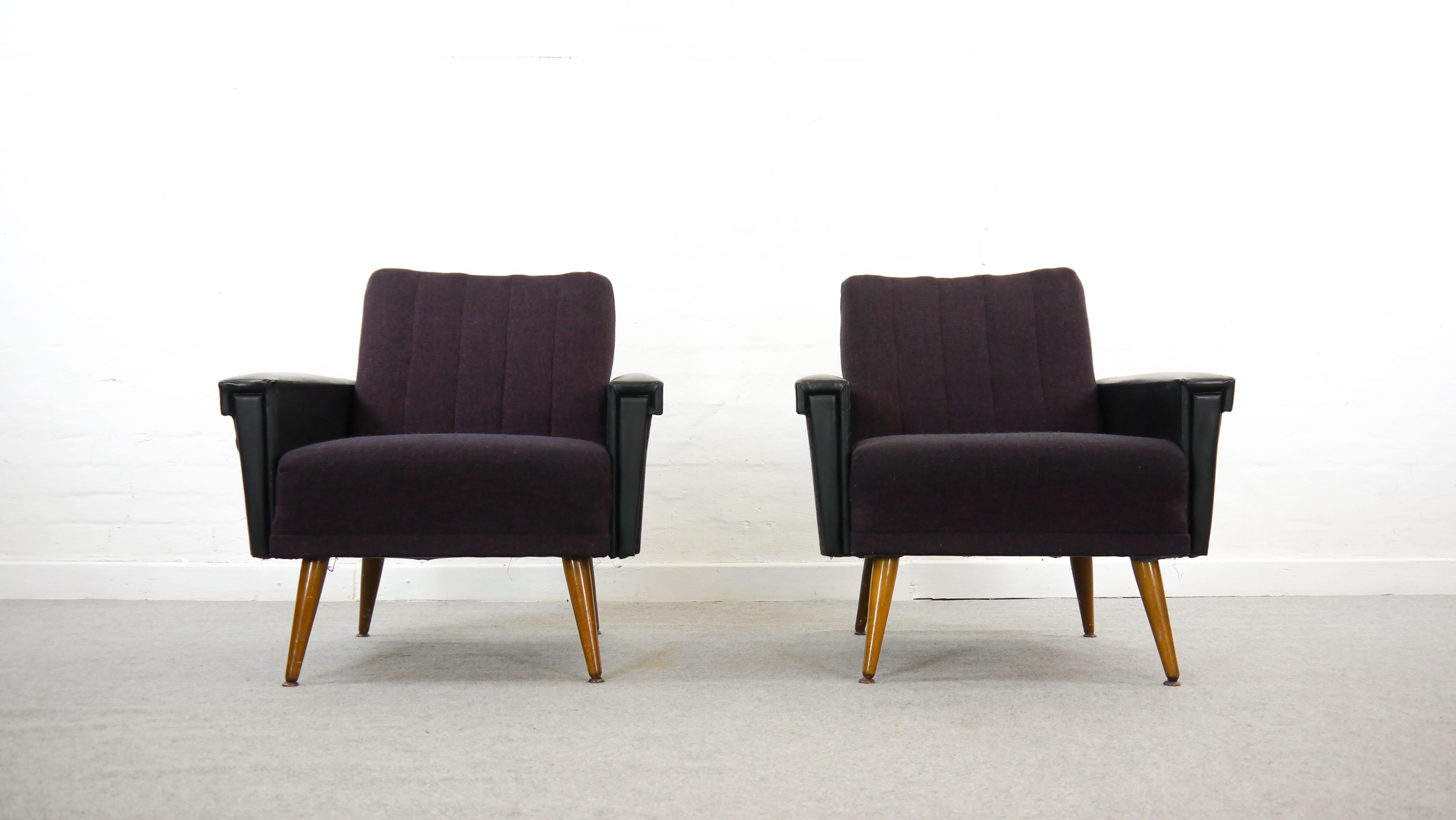 Pair (2) of armchairs or easy chairs from the 1950s-1960s. Upholstered in purple fabric and leatherette (armrests) on wooden legs. Typical charming 1950s appearance. Seating experience is good. Designer and manufacturer unknown.