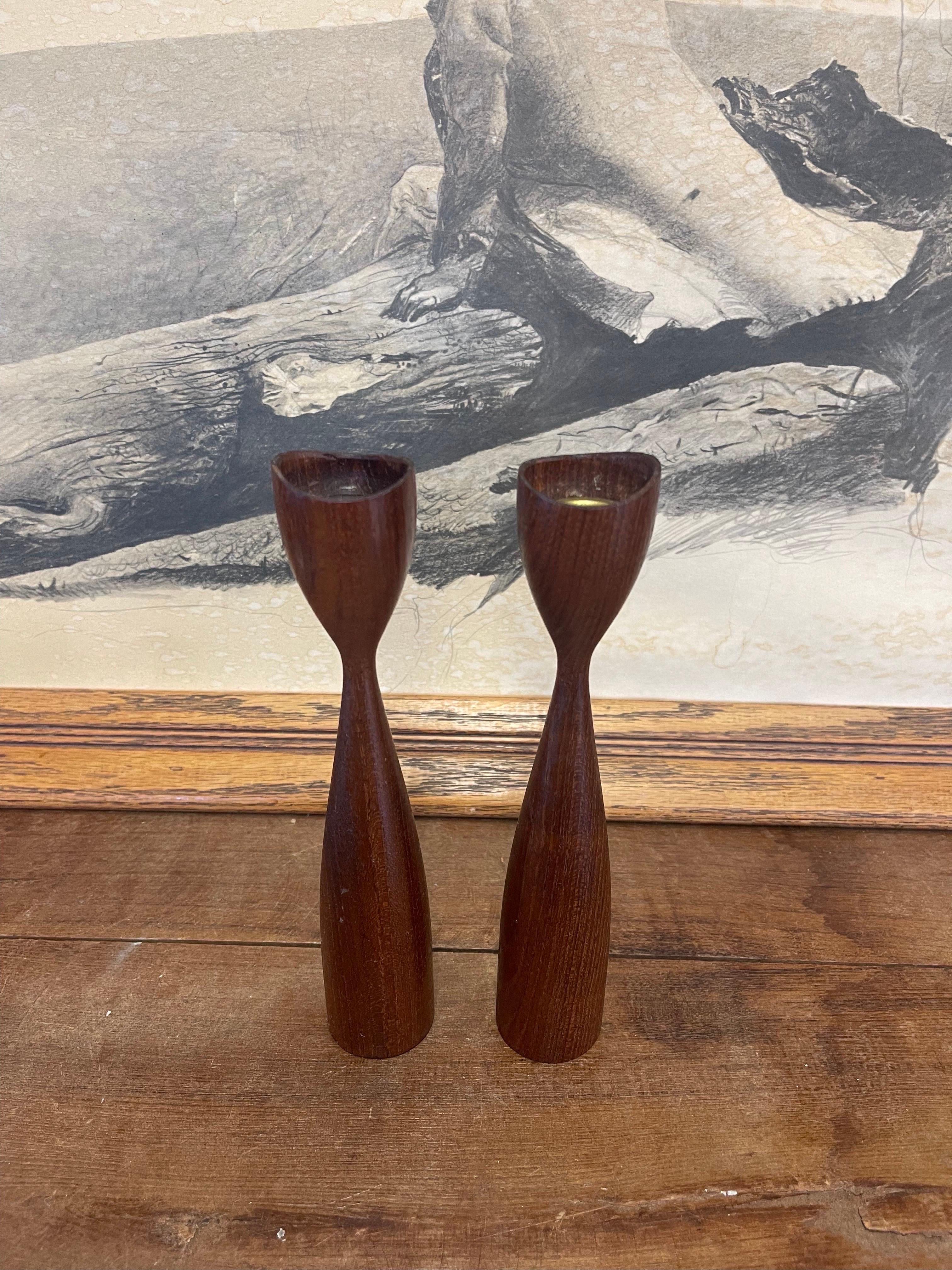 Walnut Toned Decorative Candle Stick Holder. Atomic Design. Circa 1960s- 1970s. Possibly Teak. The Inner Metal Piece is missing from one of the Holders as Shown. Vintage Condition Consistent with Age as Pictured.

Dimensions. 2 W ; 2 D ; 9 H