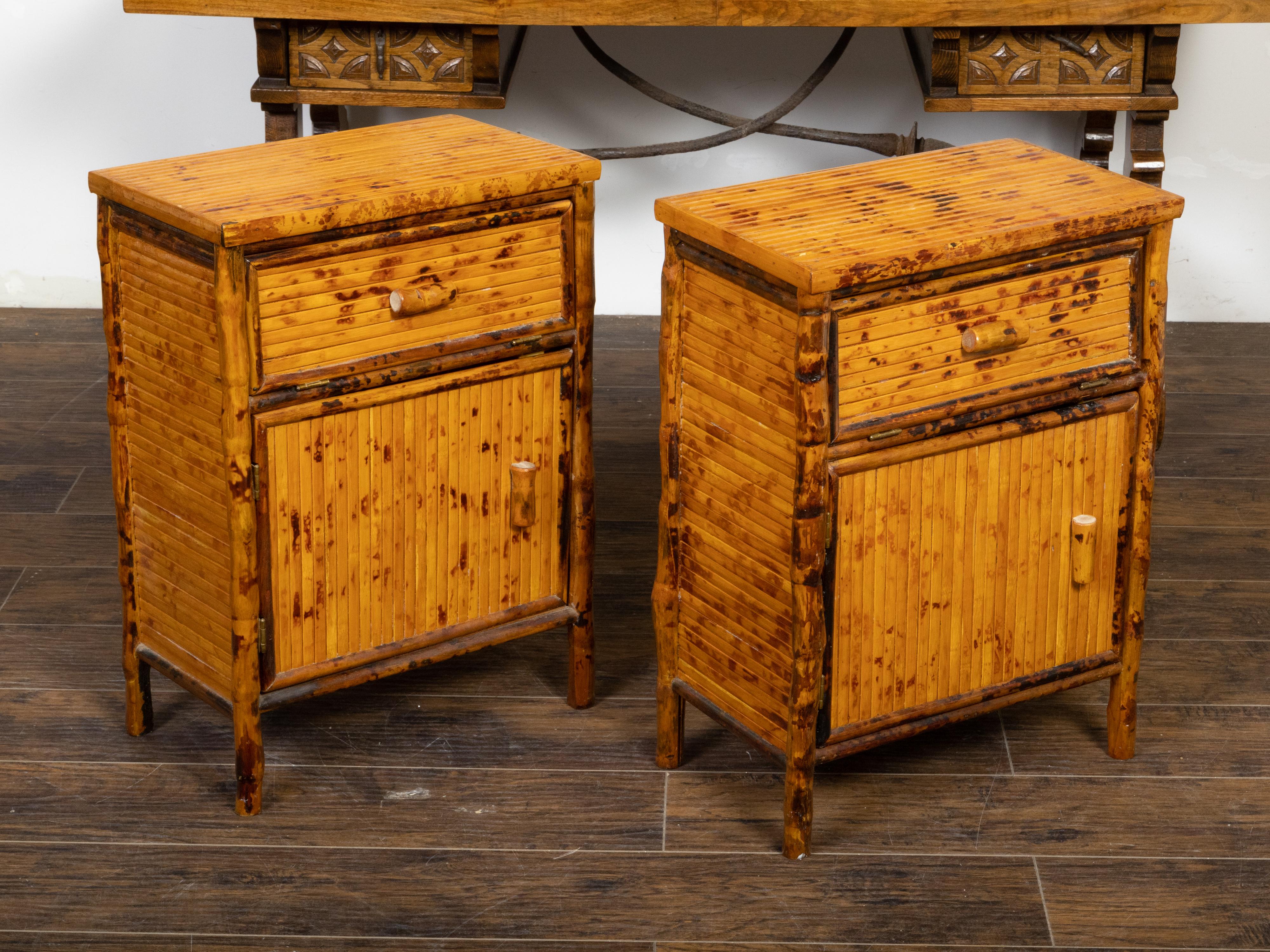A vintage pair of English bamboo bedside cabinets from the mid 20th century with doors and rustic appearance. Created in England during the Midcentury period, each of this pair of bedside cabinets features a bamboo over wood structure boasting a