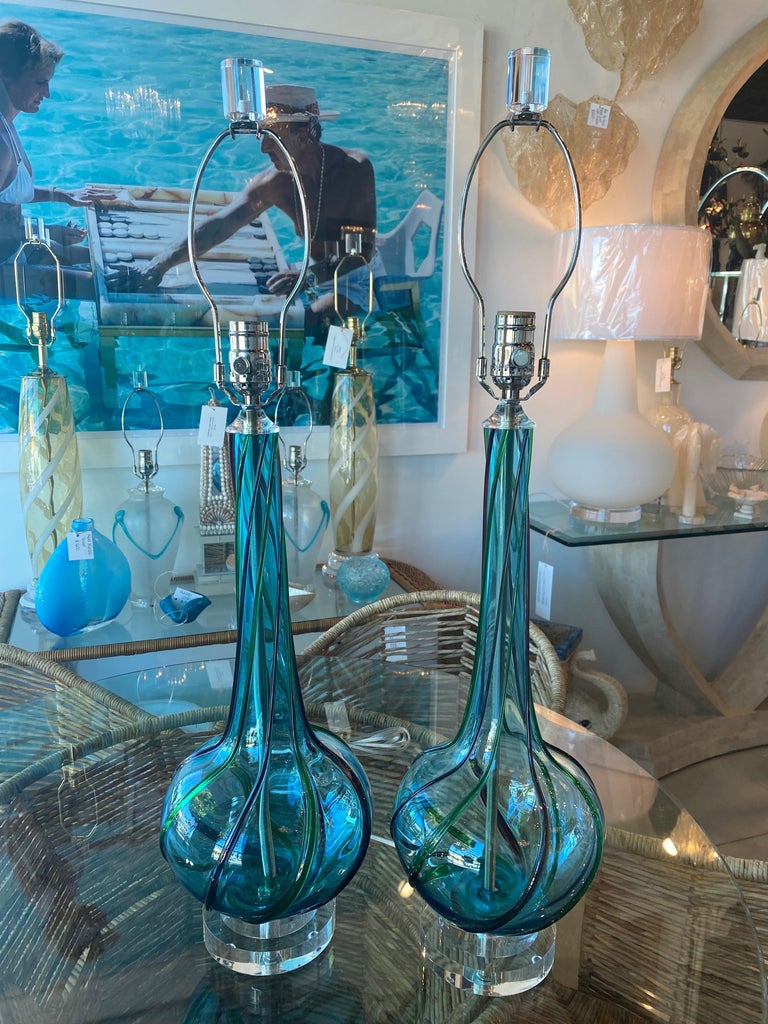Beautiful pair of vintage Murano glass aqua ribbon table lamps. Perfectly restored. Double lucite base, lucite finial, all new 3 way sockets, nickel hardware, lucite vase cap. Dimensions: 22.5 H to socket x 30 H to finial x 8 D.