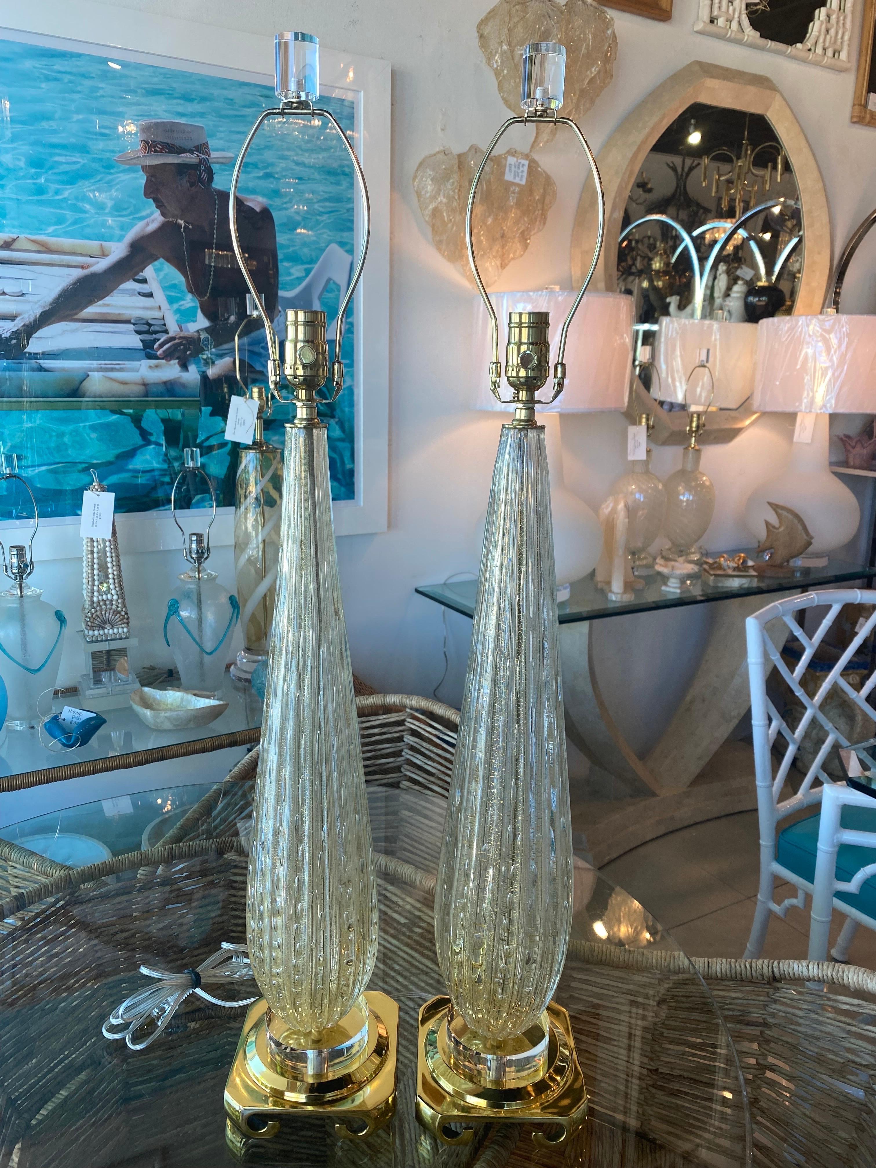 Amazing pair of vintage Murano Seguso glass table lamps with bubbles inside and gold flecks. These have been restored to perfection. Newly wired, new solid brass ming base, lucite break, lucite finial, 3 way sockets in brass. Dimensions: 27.5 H to