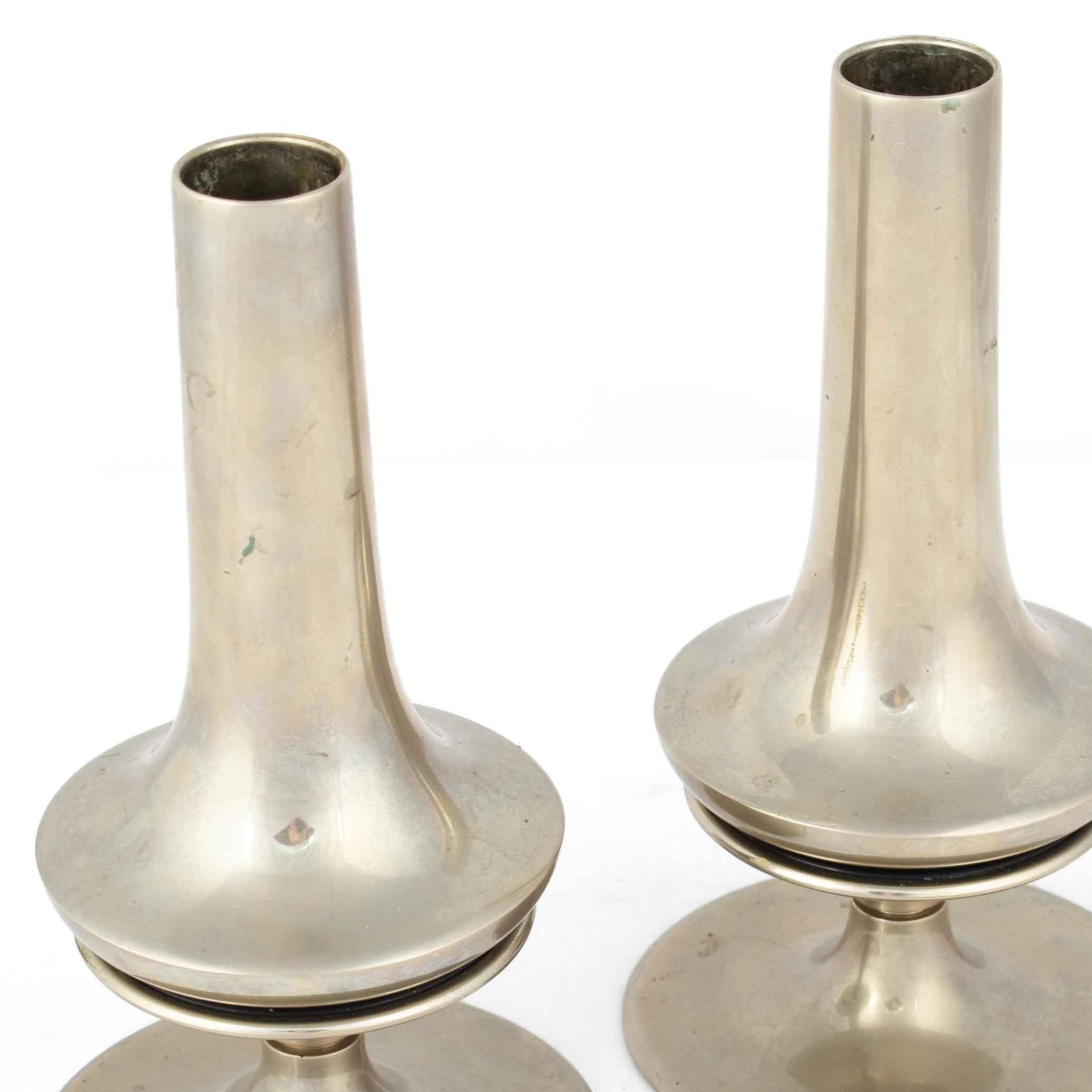 Pair of candlesticks is an original pair of decorative objects realized in the Early XX Century. 

Original nickel-plated metal. 

Marked R on the base. 

Good conditions: slight signs of age. 

Very beautiful pair of objects that consists