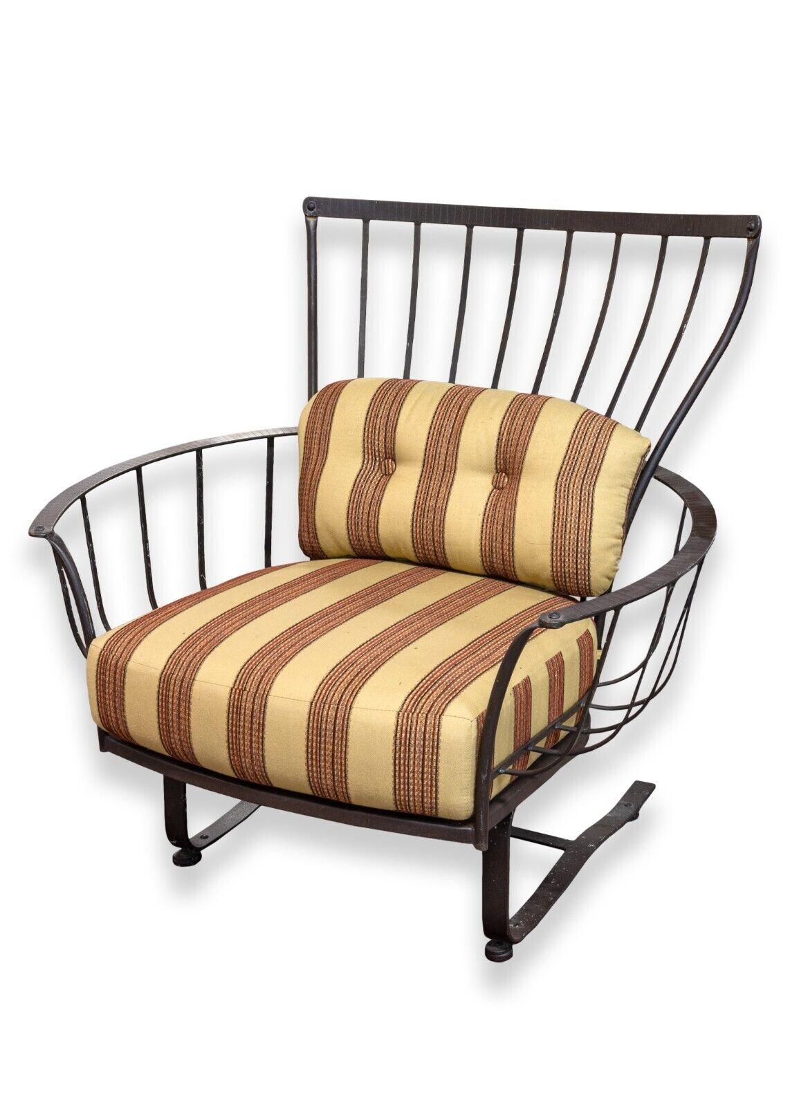 Vintage pair of OW Lee wrought iron oversized patio rocking chairs with cushions. This a lovely and unique set of patio rocking chairs. These chair feature a black wrought iron construction with included original brown cushions. These chairs have a