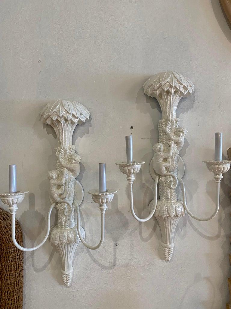 Amazing pair of vintage monkey palm tree frond leaves wall light sconces. These have been newly lacquered in white. New candelabra covers. Dimensions: 26 H x 15 W x 7 D.