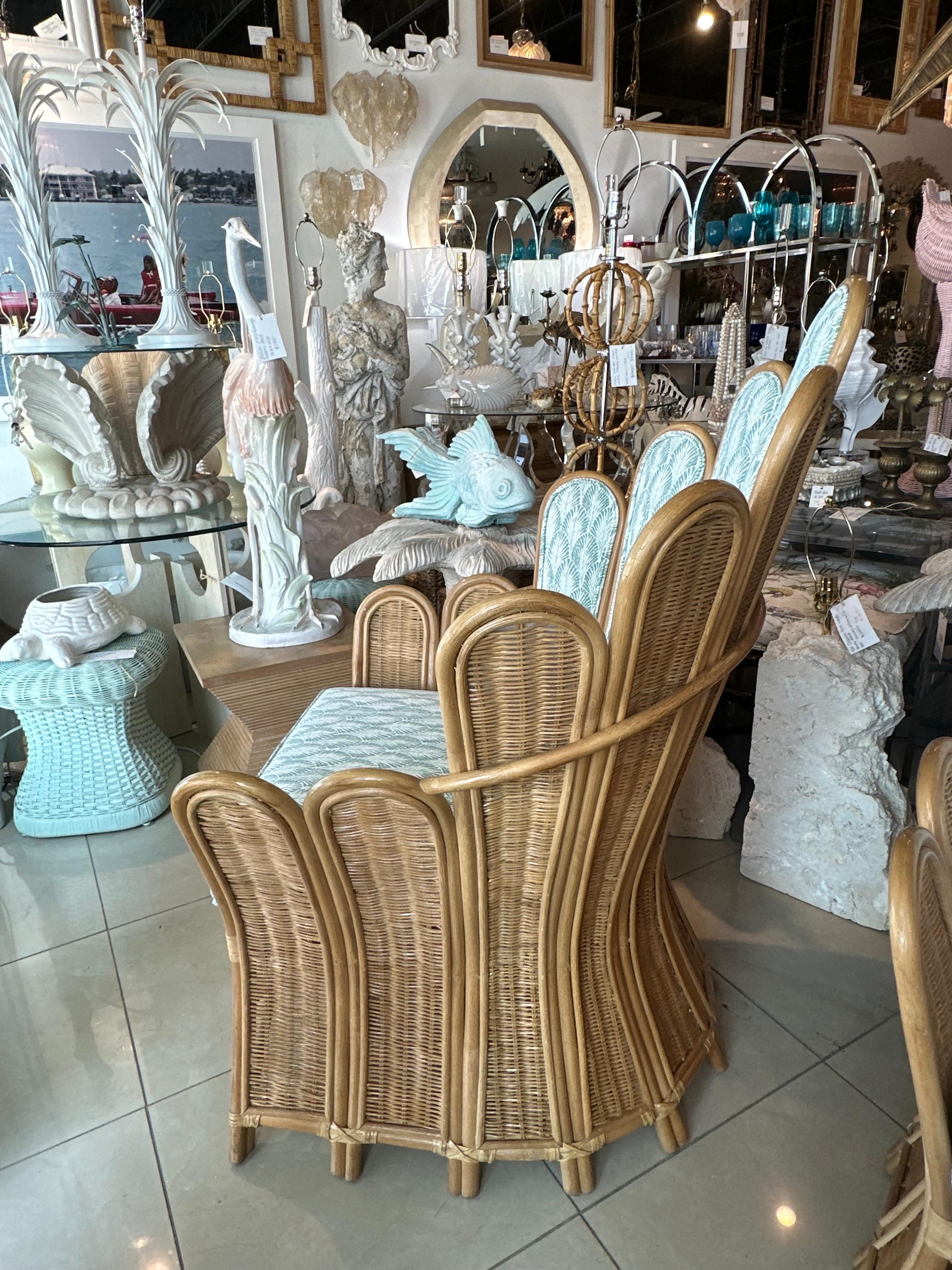 Lovely pair of vintage 1970s wicker and rattan peacock fan back palm frond arm chairs. These retain their original rattan finish that is in wonderful condition with no damage, breaks or defects. These have been newly, custom upholstered. 