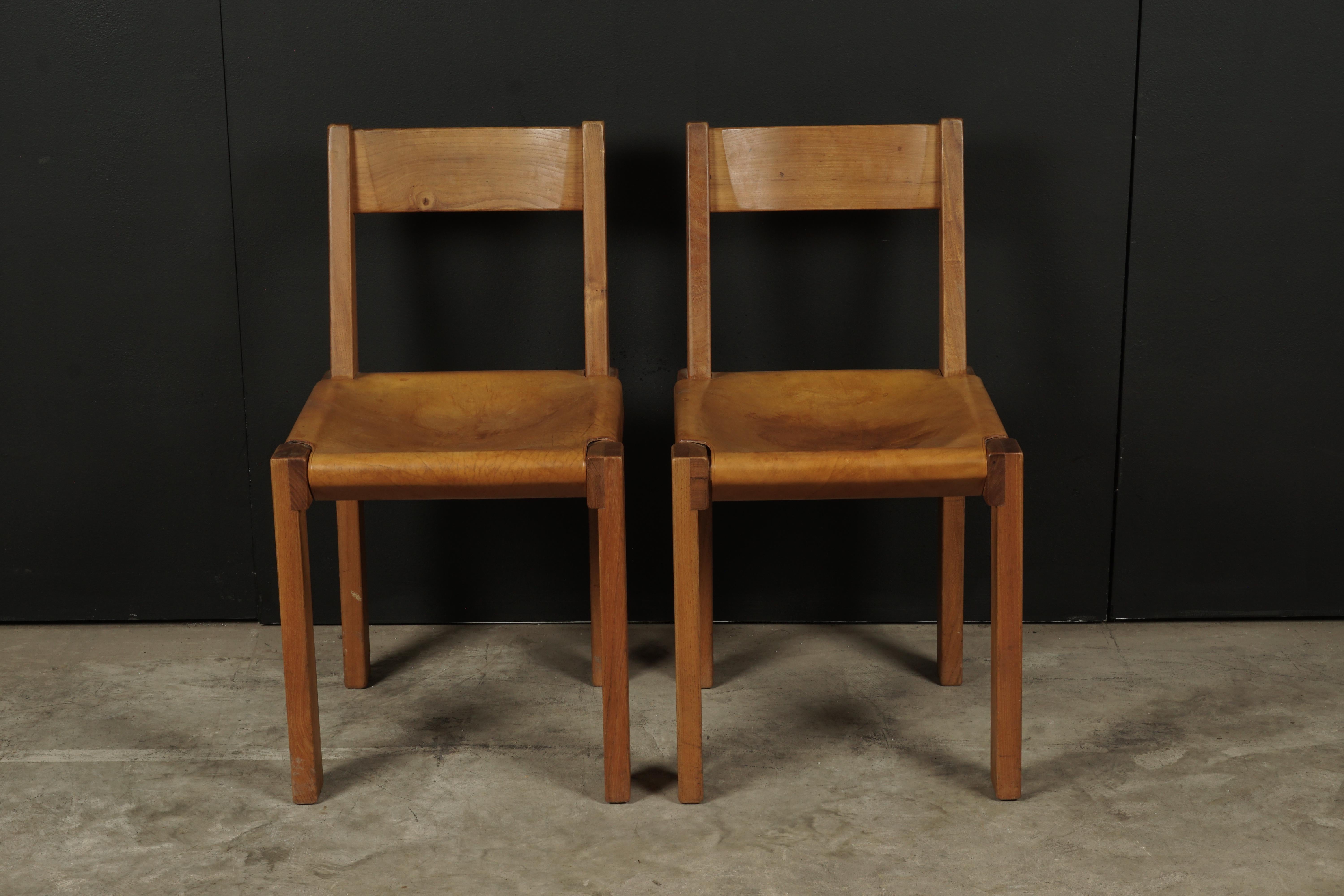 Vintage pair of Pierre Chapo chairs model S24, France circa 1970. Solid elm construction with thick cognac leather. Great patina.