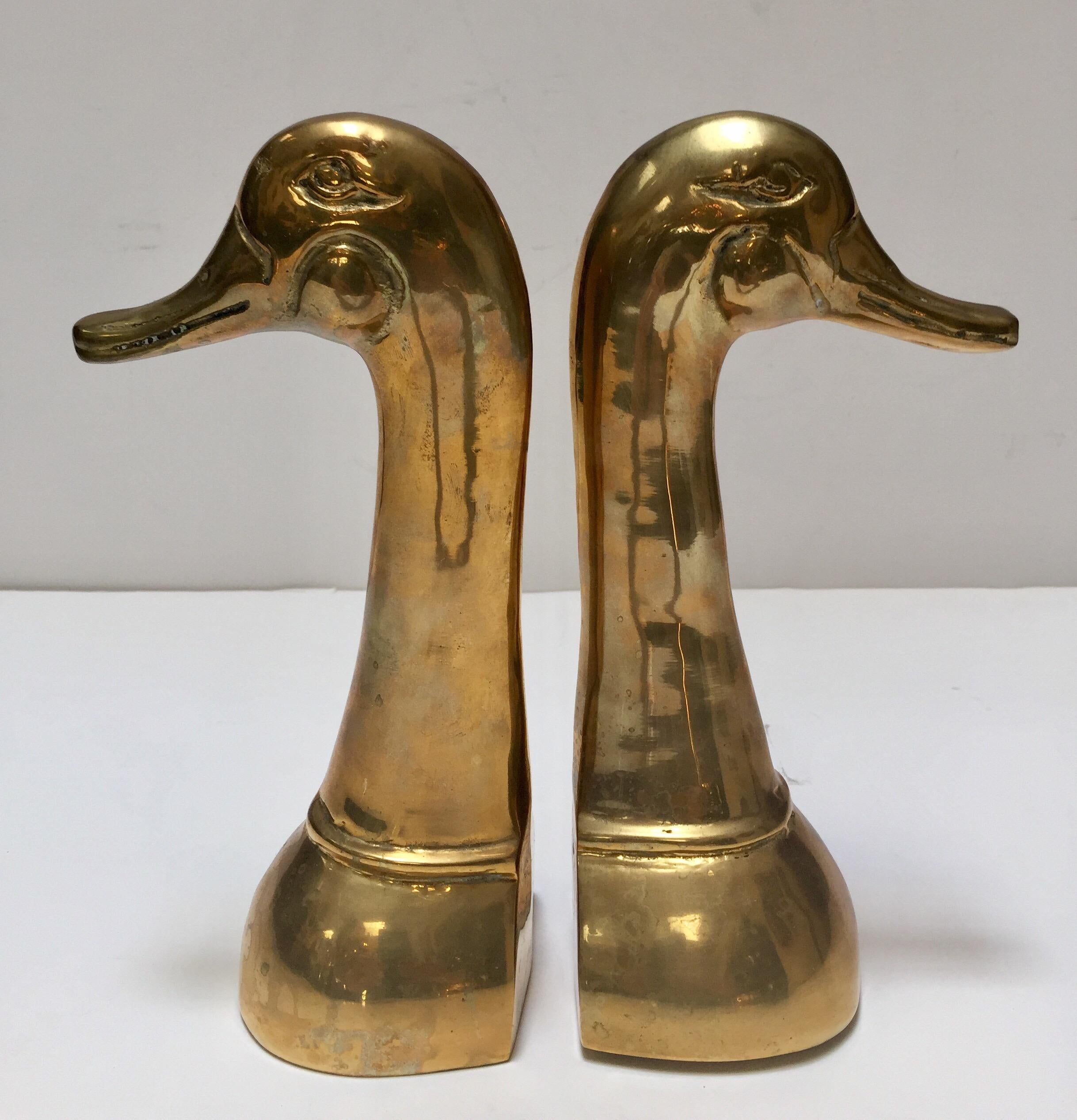 Pair of polished decorative brass duck bookends in Sarried style.
Set of midcentury vintage cast metal brass duck sculpture bust bookends.
Aged warm glow patina.
Size for each is 6