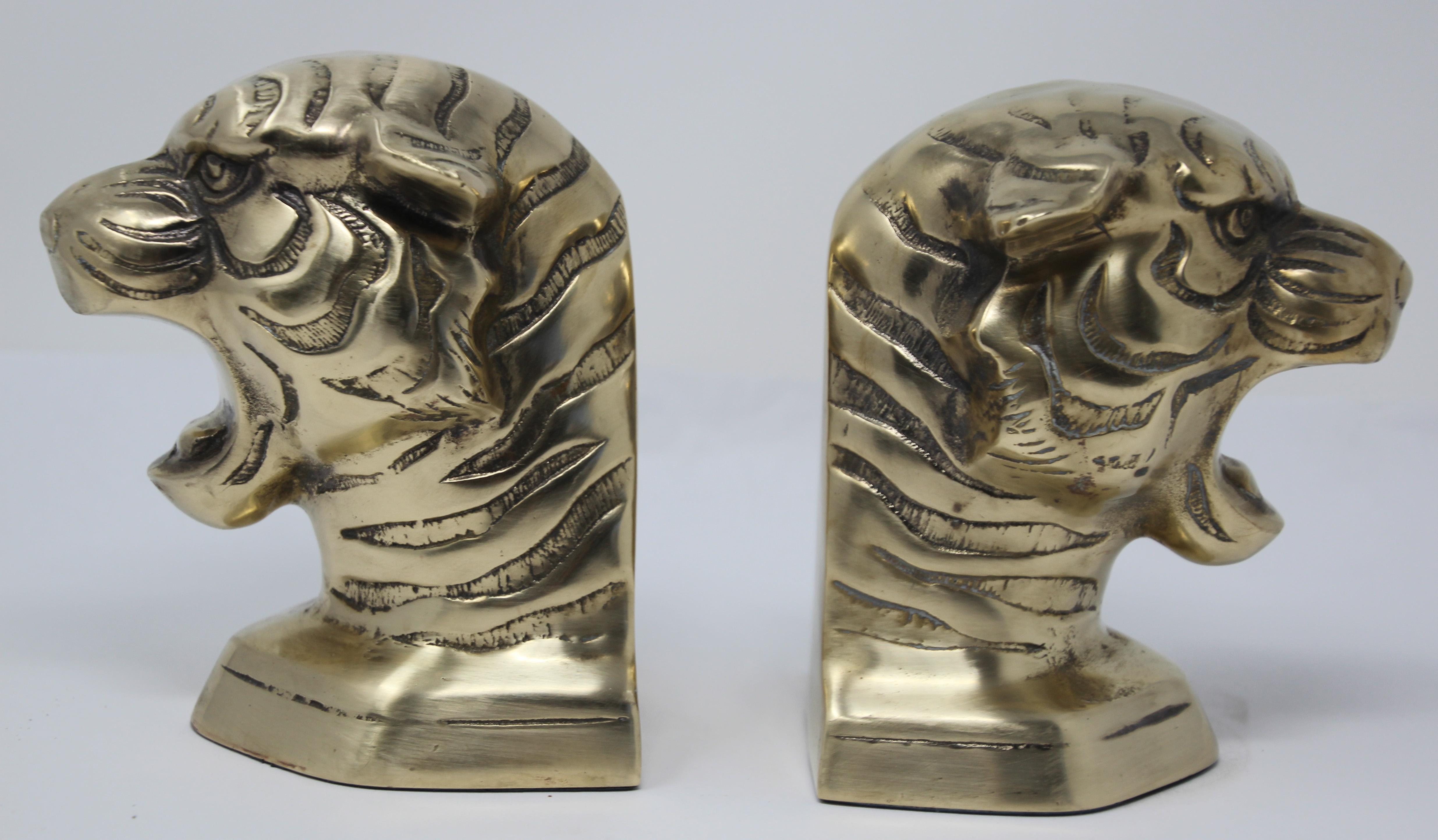 Pair of polished decorative cast polished brass tiger’s bookends, circa 1950.
Midcentury vintage cast heavy metal brass tiger’s heads sculpture bust bookends.
Size for each is 5.5