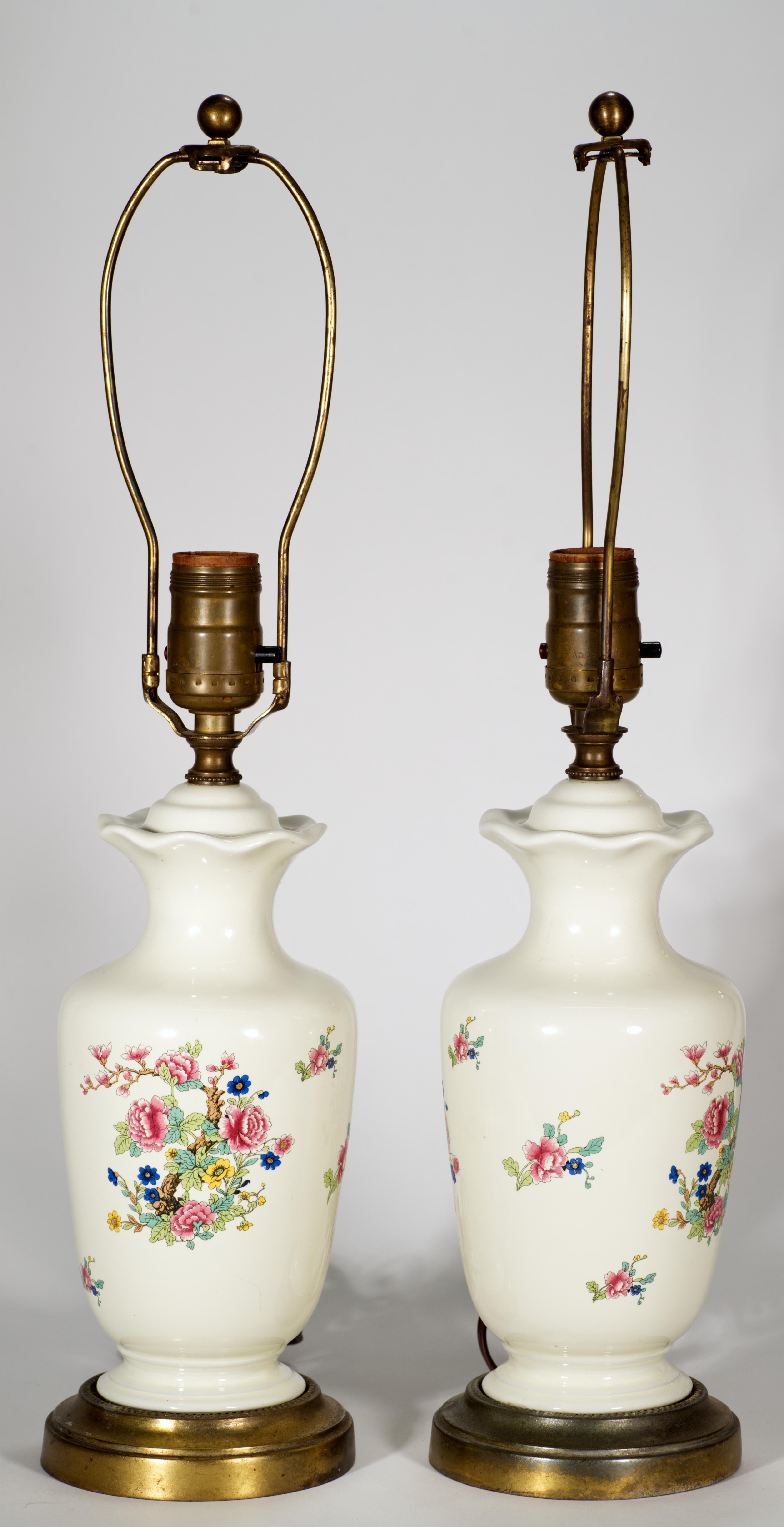  Pair of vintage accent or table lamps feature a variation of the iconic Pembroke pattern; urn-shaped porcelain bodies are mounted on round ornamental brass bases and set with brass fittings.

Pembroke is an instantly recognizable decor and