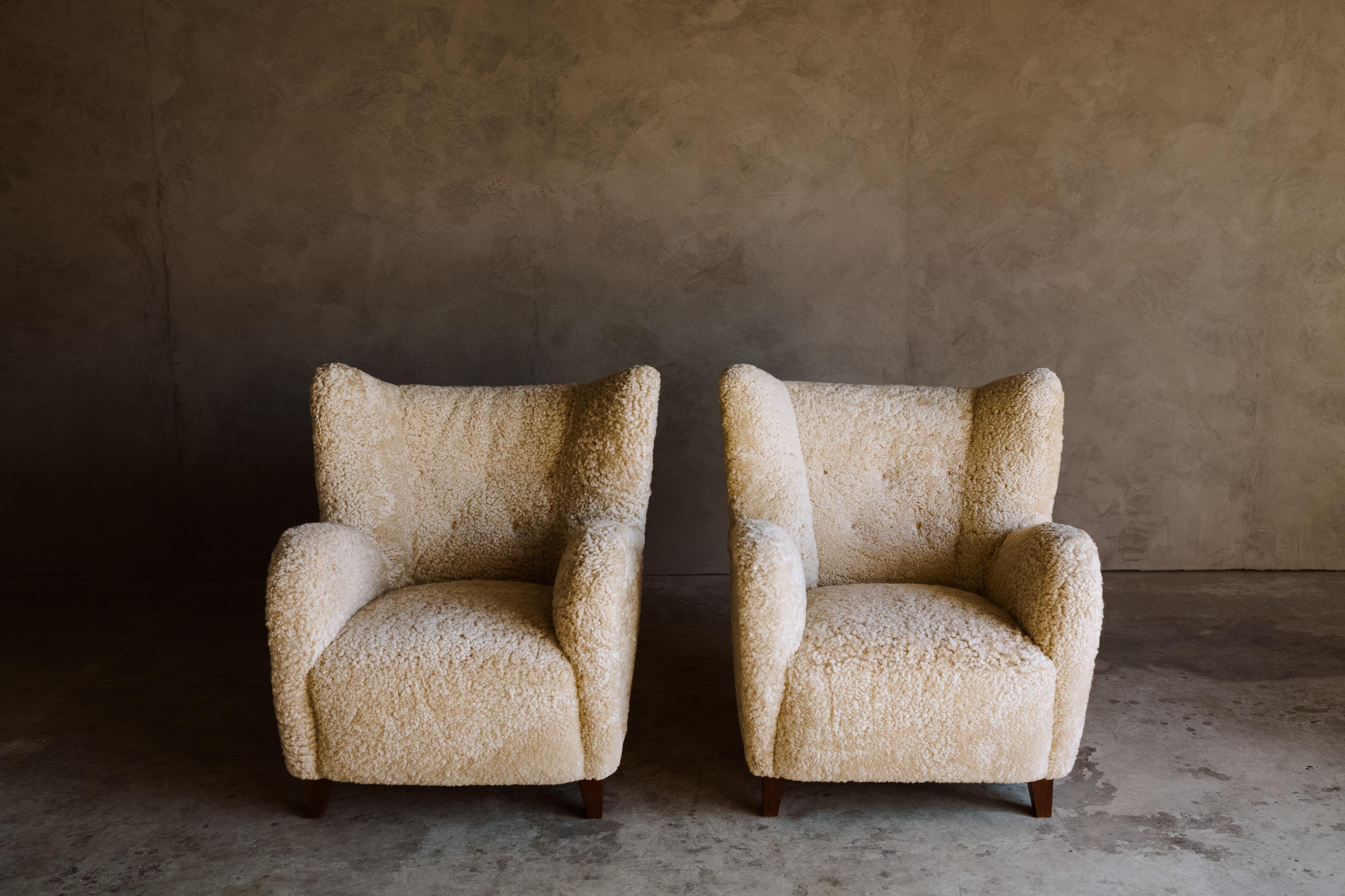 Vintage pair of sheepskin lounge chairs from Finland, circa 1950. Cabinetmaker designed with very soft light sheepskin upholstery and leather buttons. Professionally reupholstered in Denmark. Excellent condition.